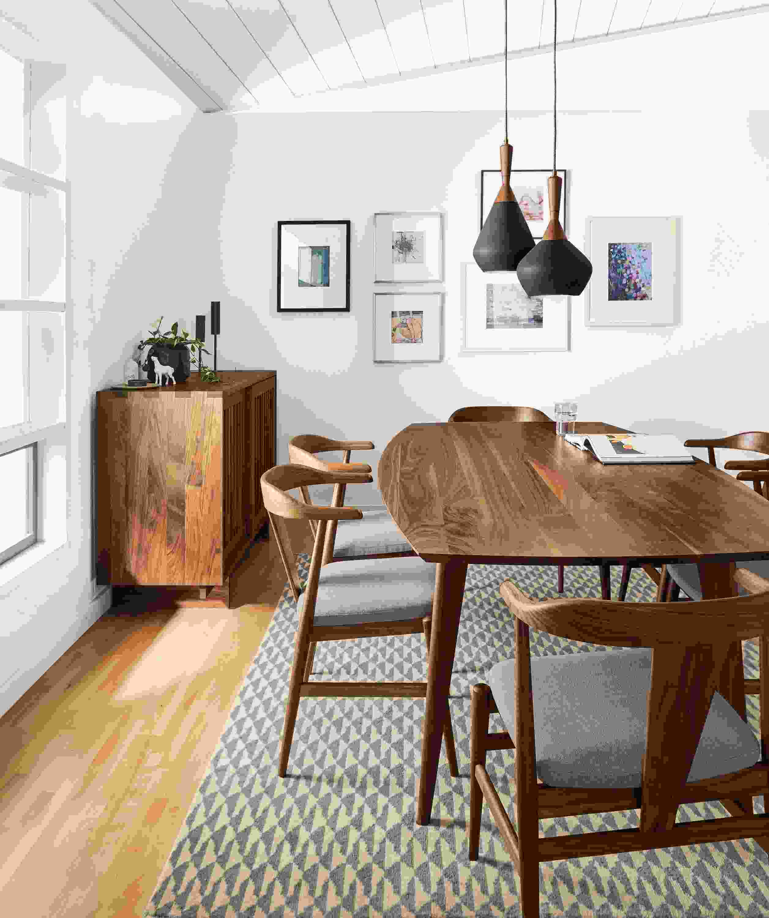 Dining room with Ventura dining table in walnut and Evan arm chairs in walnut with Flint Cement cushions.
