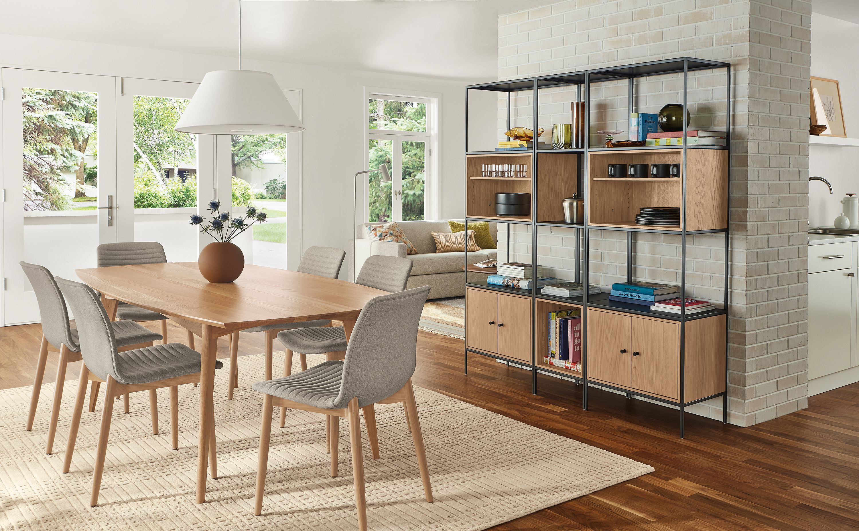 Dining room with Ventura 84-wide table in rye on red oak, Cato chairs, and Slim 5 insert wall unit in natural steel and rye on red oak.