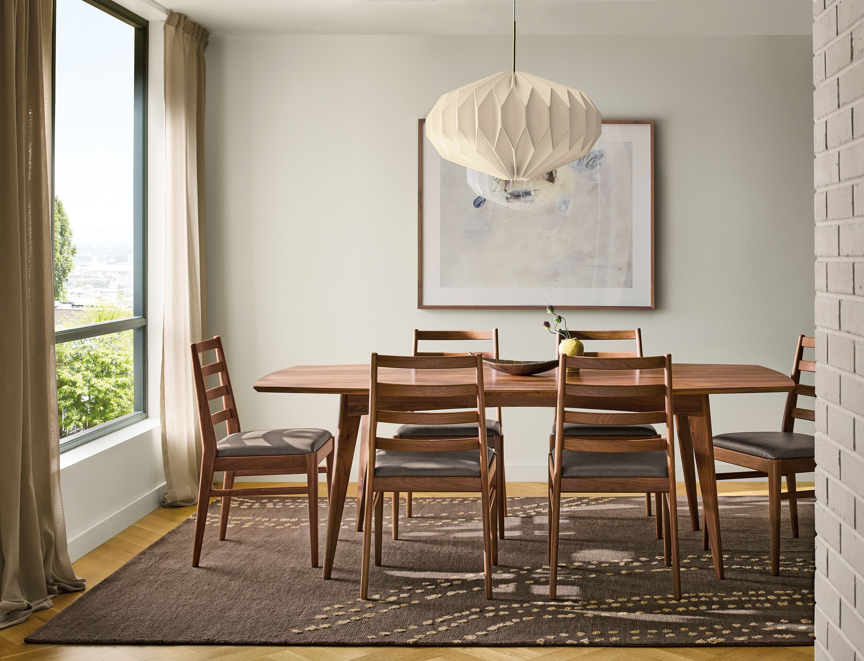 Dining room with 84-wide Ventura table and 6 Conway chairs all in walnut and Sitara 8 by 10 rug in gold.