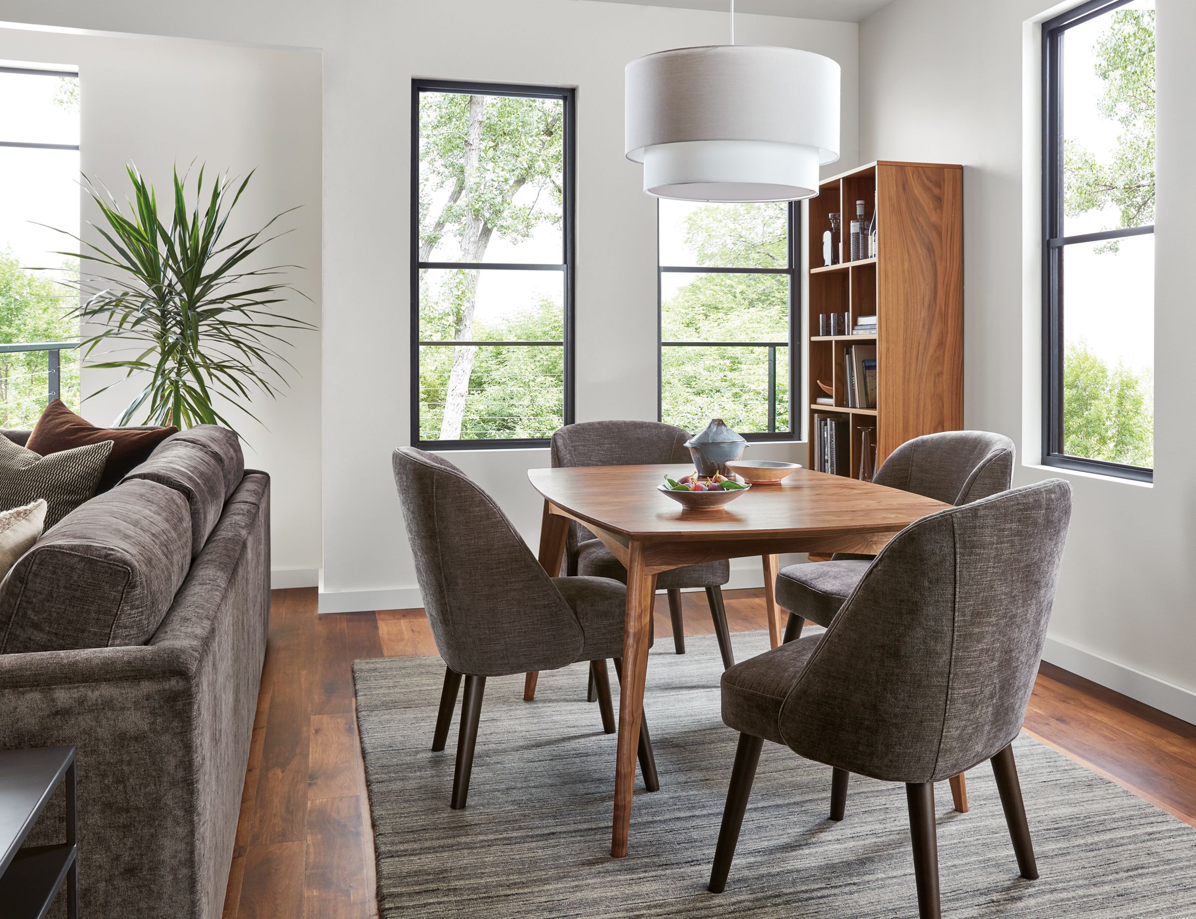 dining room with ventura extension table in walnut, cora chairs in mori charcoal, leighton pendant.