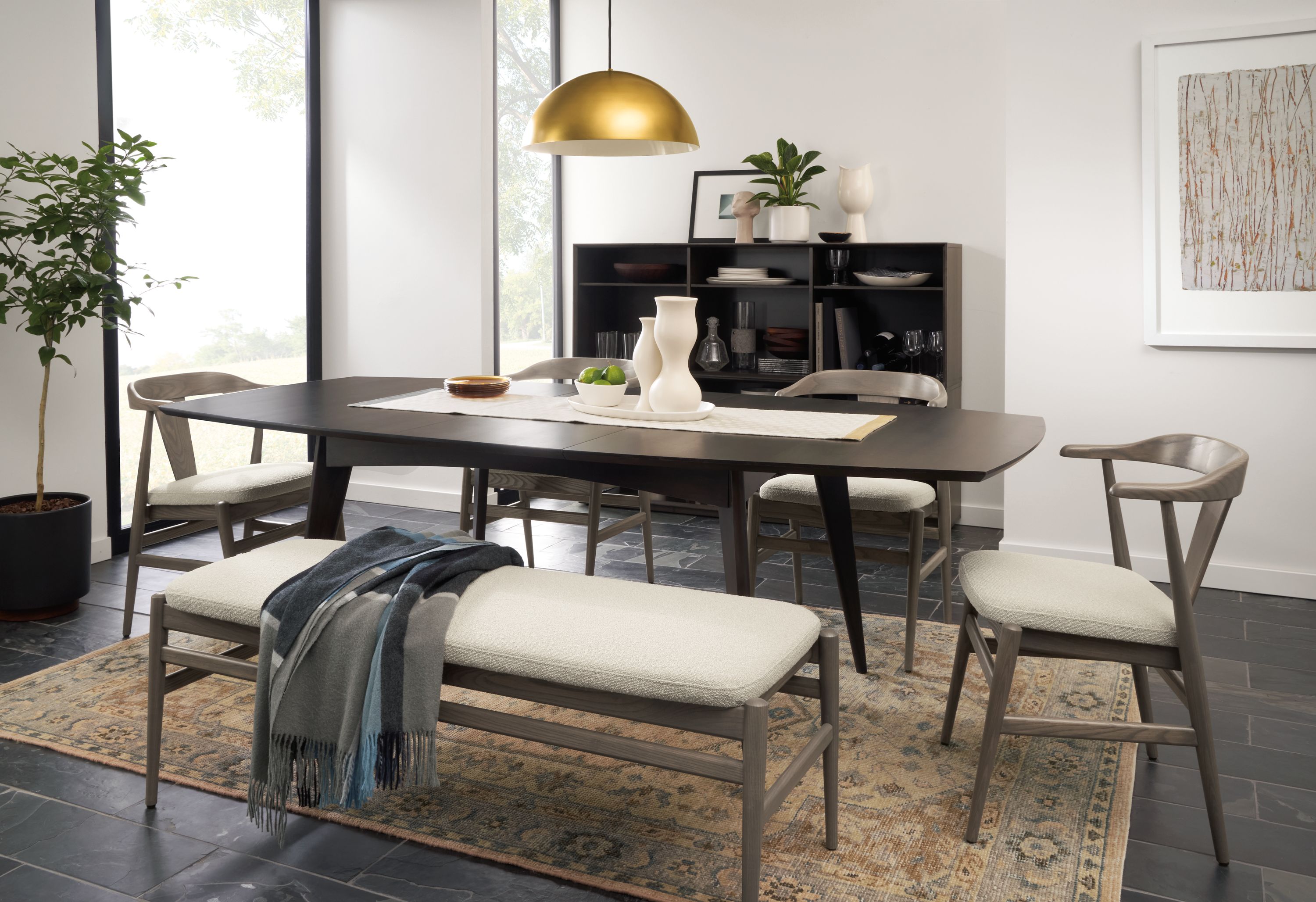 room setting including ventura dining extension table with 6 evan arm chairs, evan bench, veda rug.