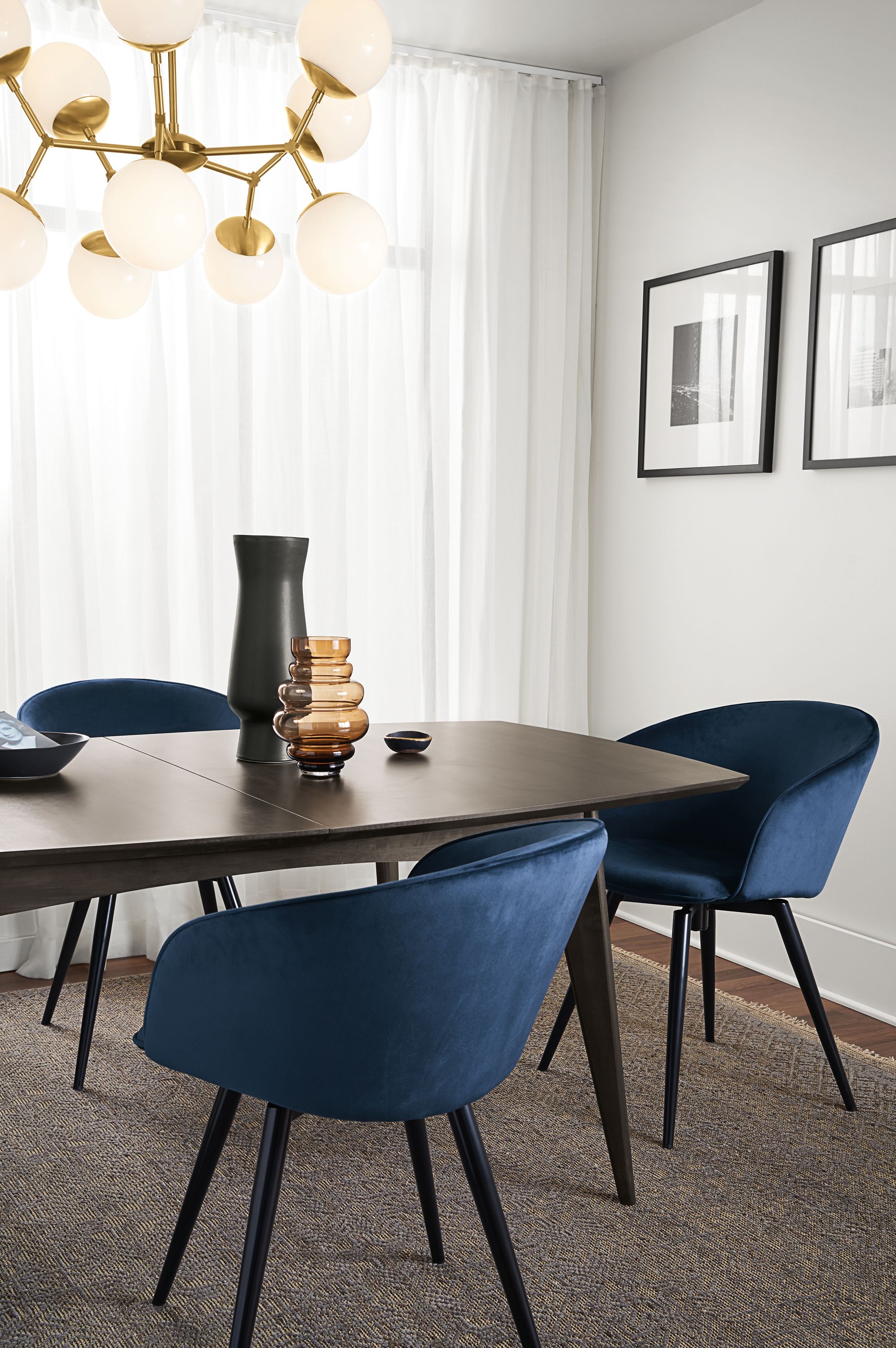 room setting including  ventura extension table, sylvan swivel side chairs, anu rug, cosma chandelier.