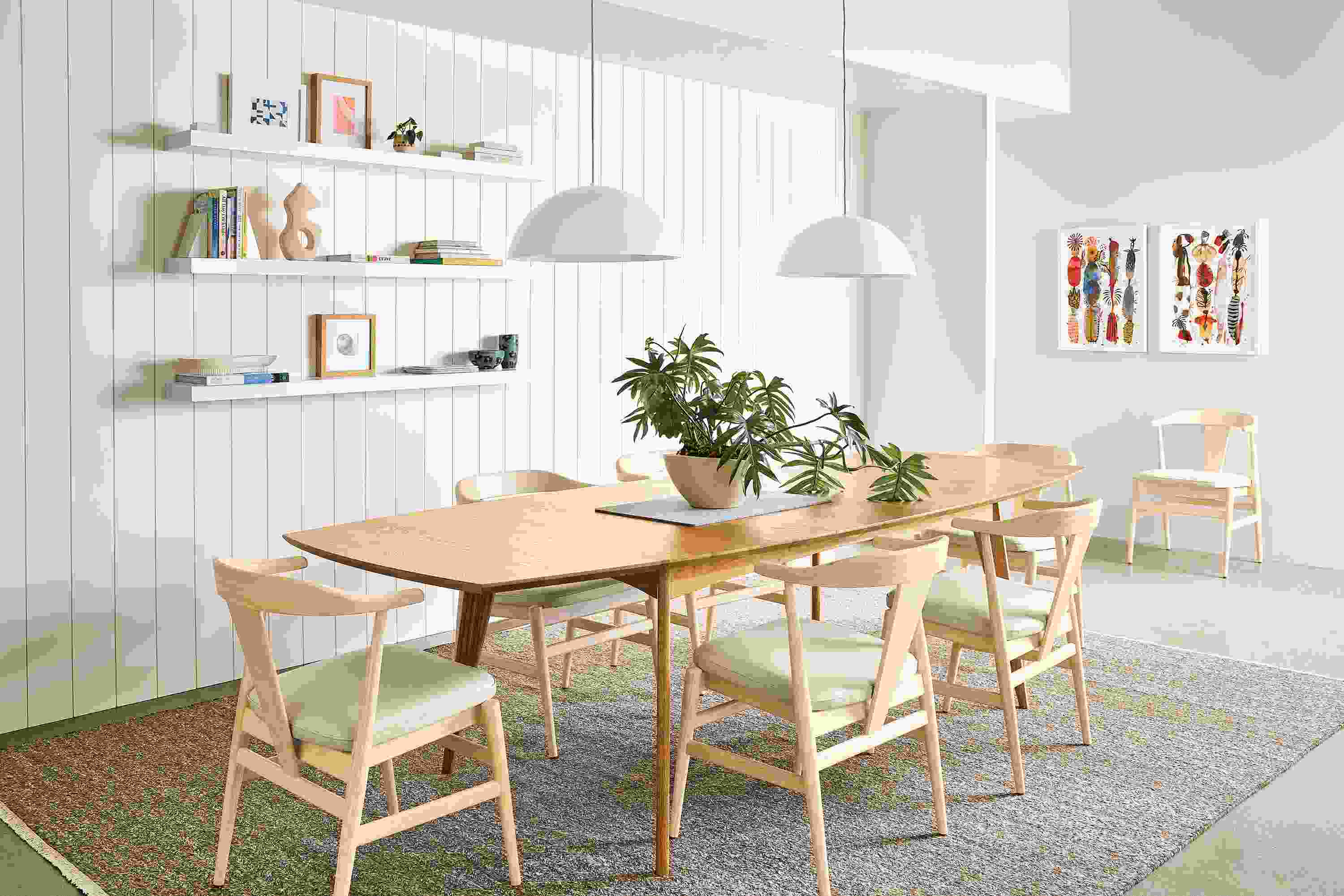 Dining room with Ventura 84-wide table in white oak and 7 Evan arm chairs in sand with pesaro ivory leather seats.