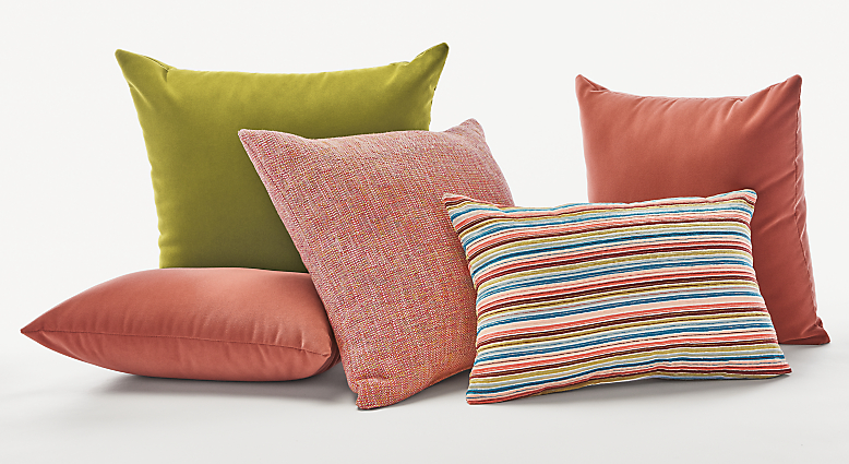 Collection of outdoor pillows in green and coral.