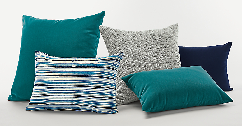 Collection of outdoor pillows in blue and teal.