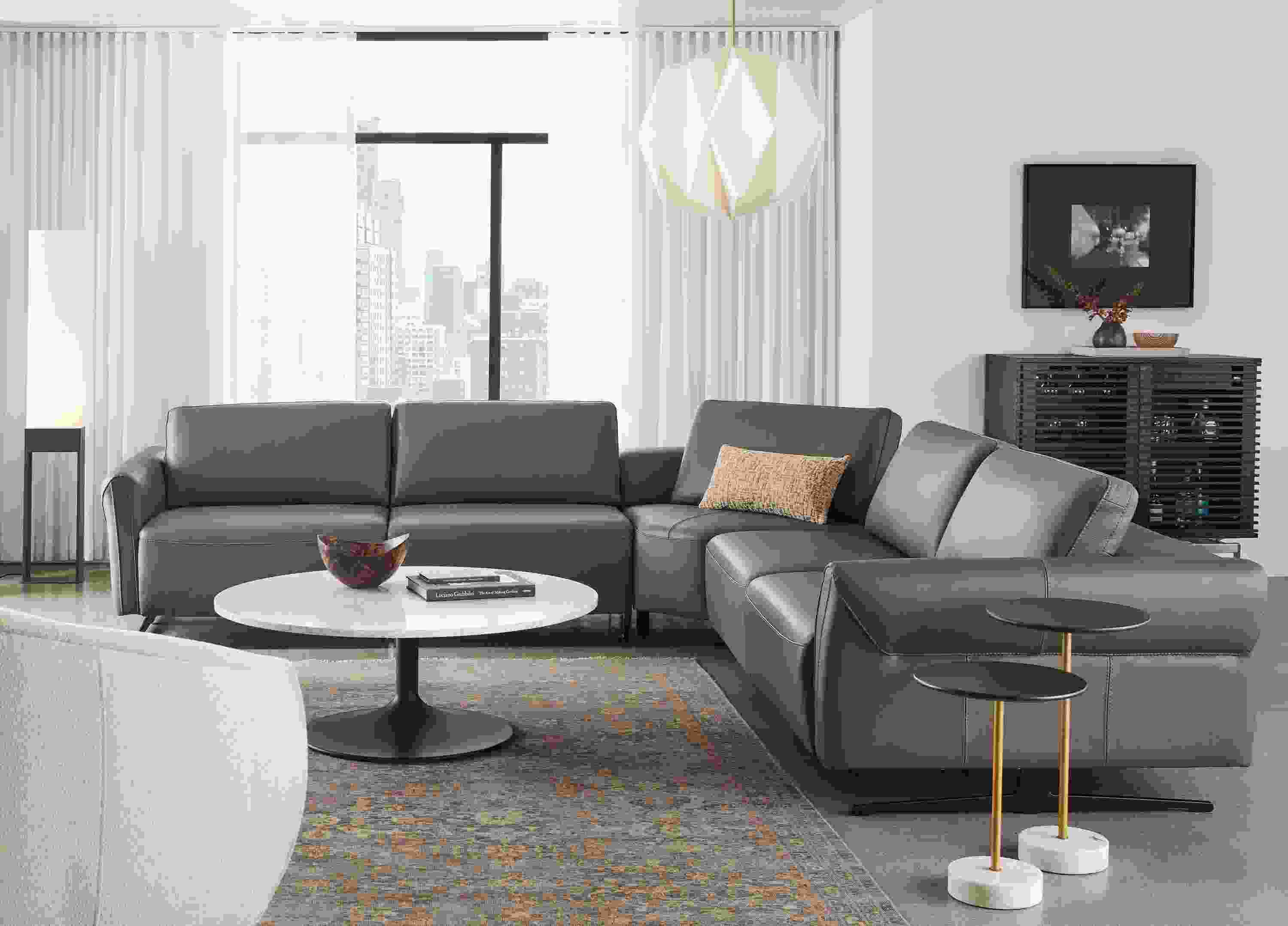 Living room with Vesna L-shaped sectional in Nikola leather with all headrests and footrests collapsed.
