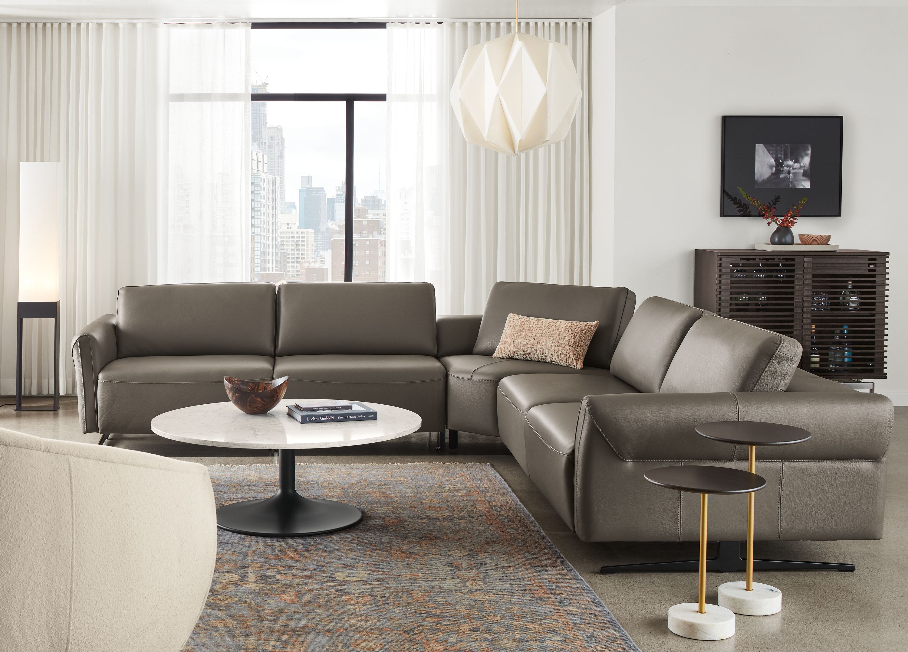 Living room with Vesna L-shaped sectional in Nikola leather with all headrests and footrests collapsed.