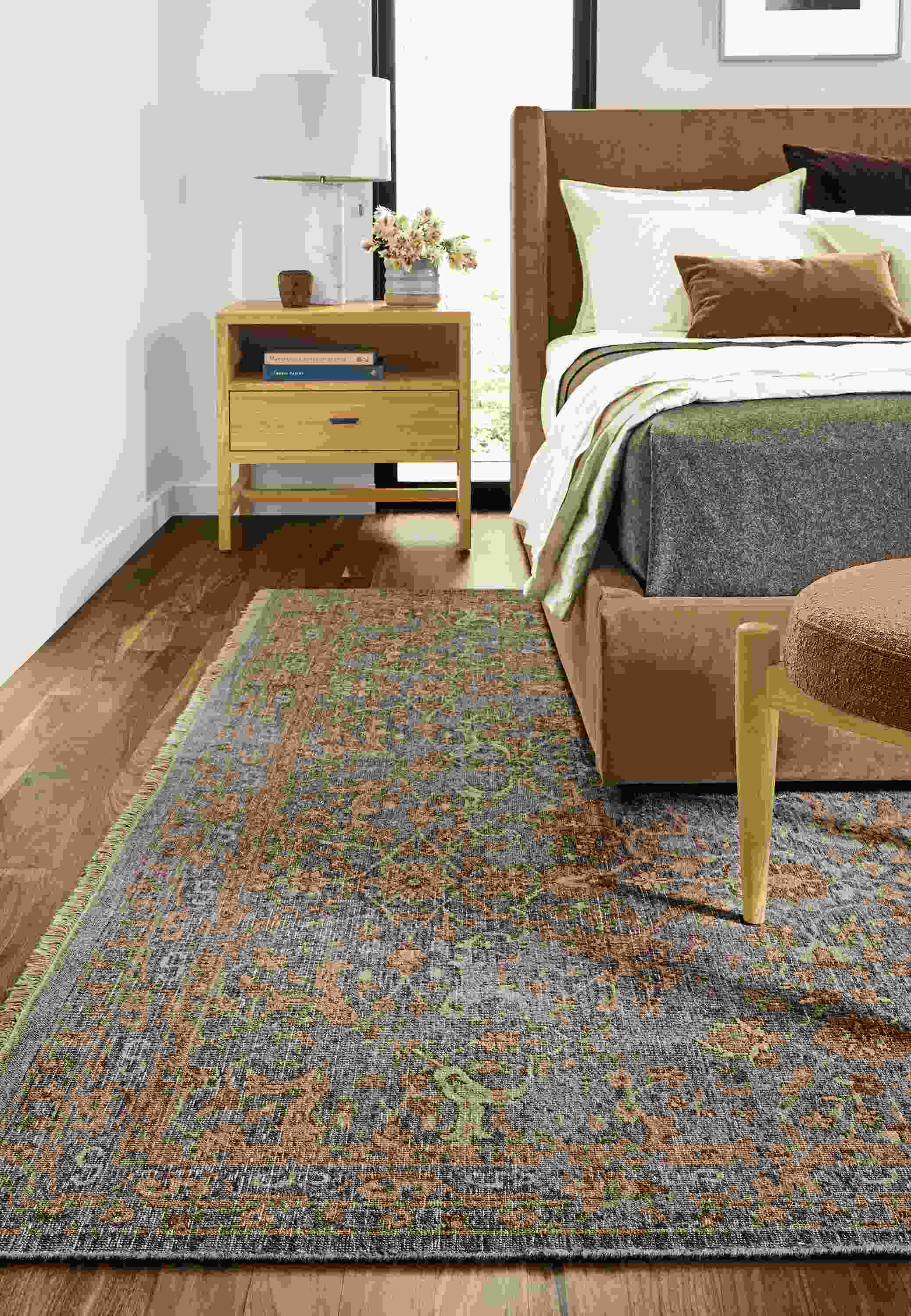 Close-up of Vesuvio rug in grey/coral in bedroom.