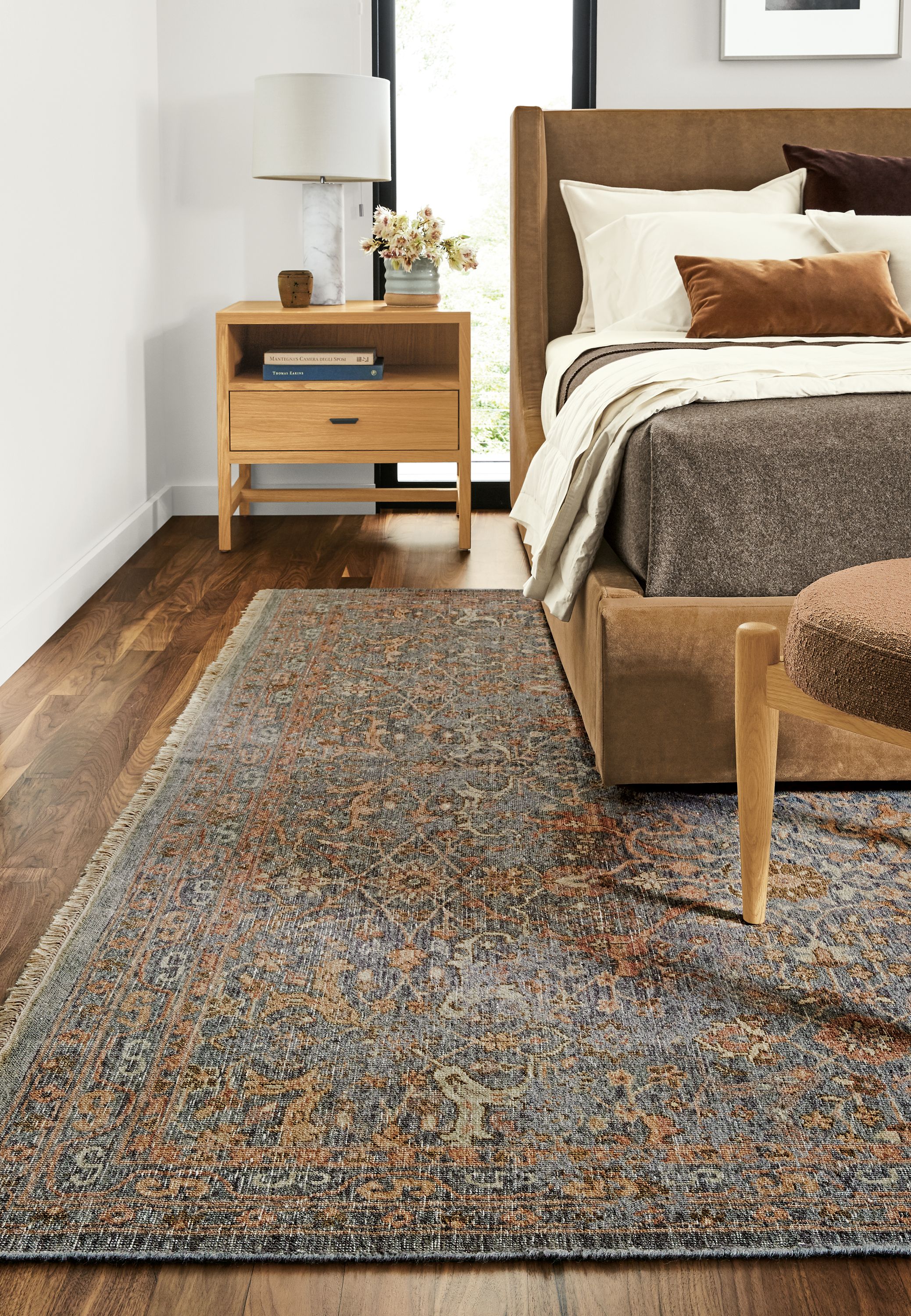Close-up of Vesuvio rug in grey/coral in bedroom.