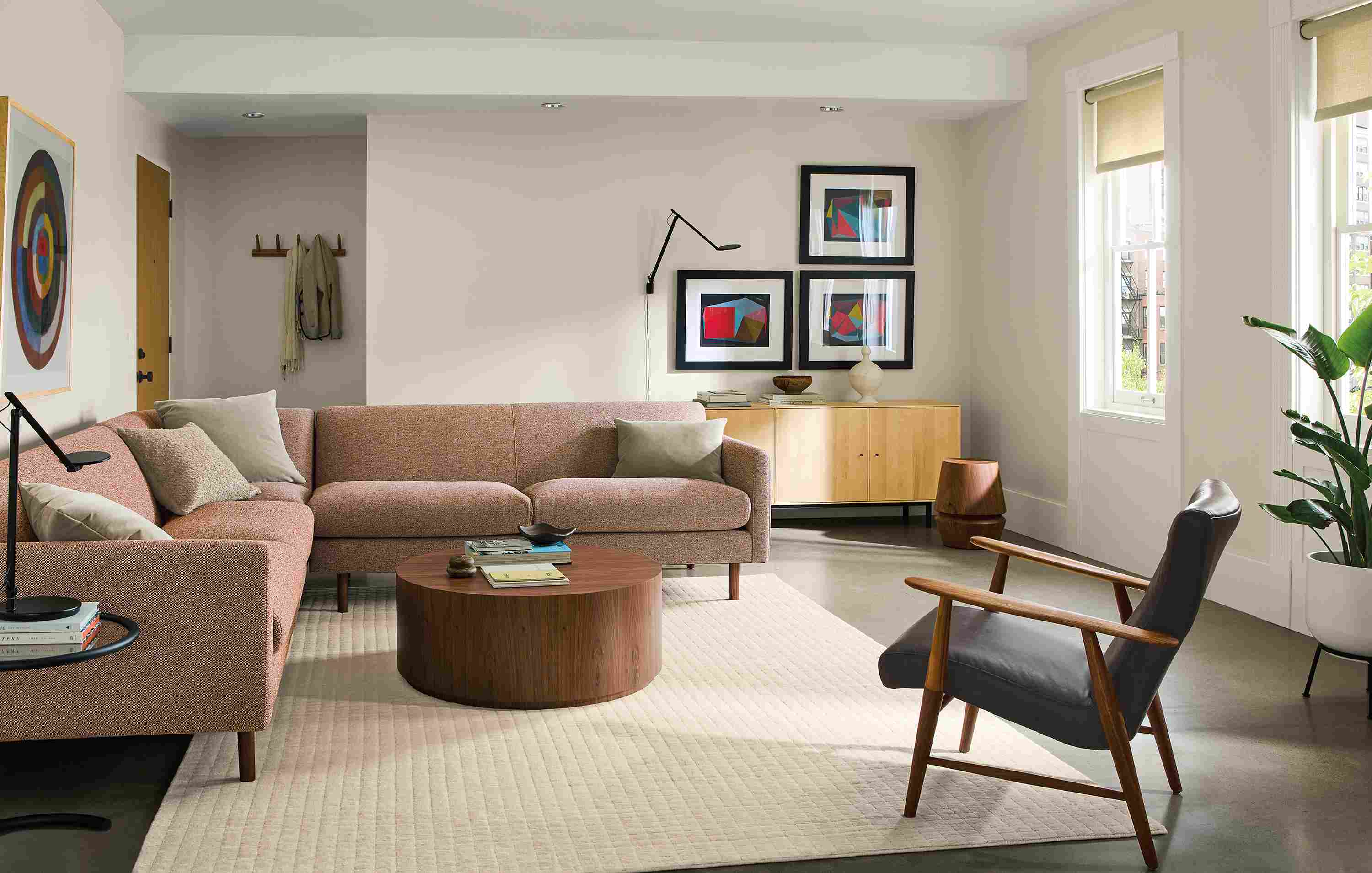 Living room with vienna 112 by 112 sectional in tatum clay, liam coffee table in walnut and nyla stool.