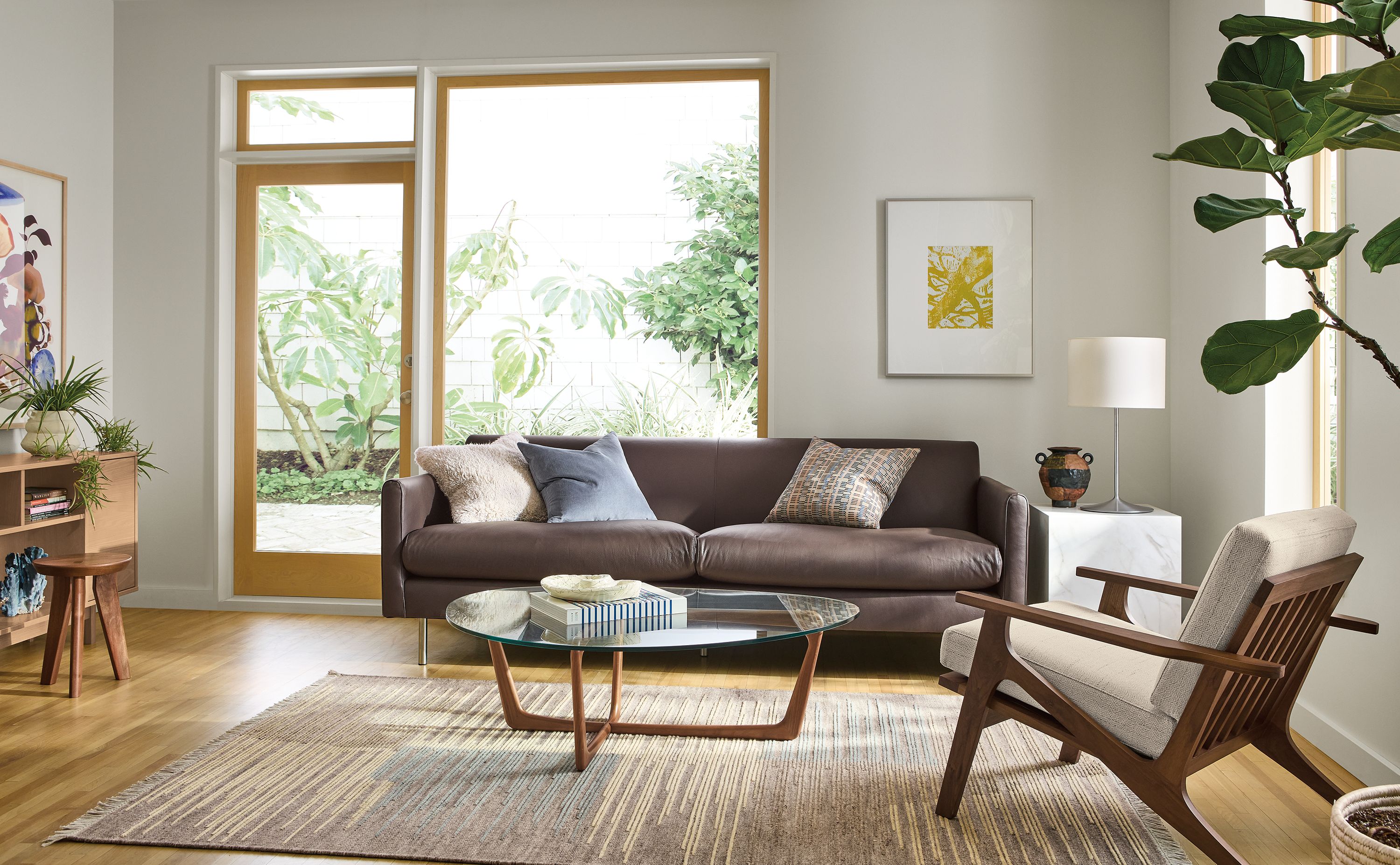 Living room with Vienna sofa in Pesaro Espresso leather, Sanna chair in Kinsey Oatmeal and Tangier rug in Natural.
