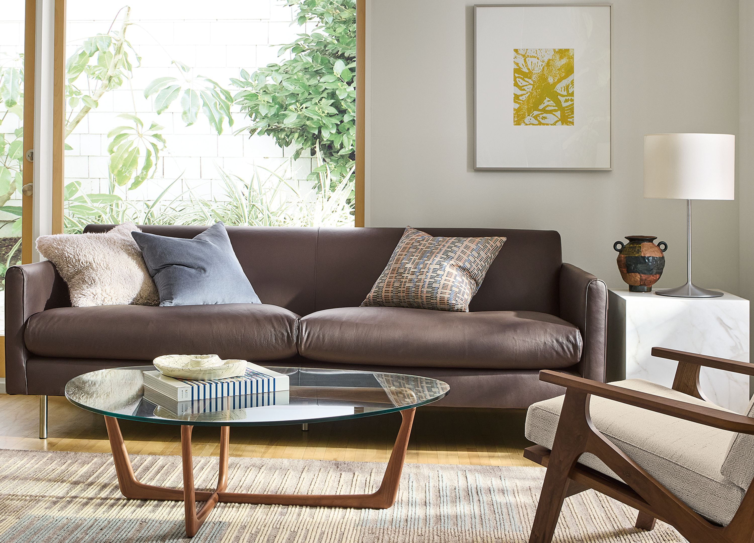 Living room with Vienna sofa in Pesaro Espresso leather, Sanna chair in Kinsey Oatmeal and Tangier rug in Natural.