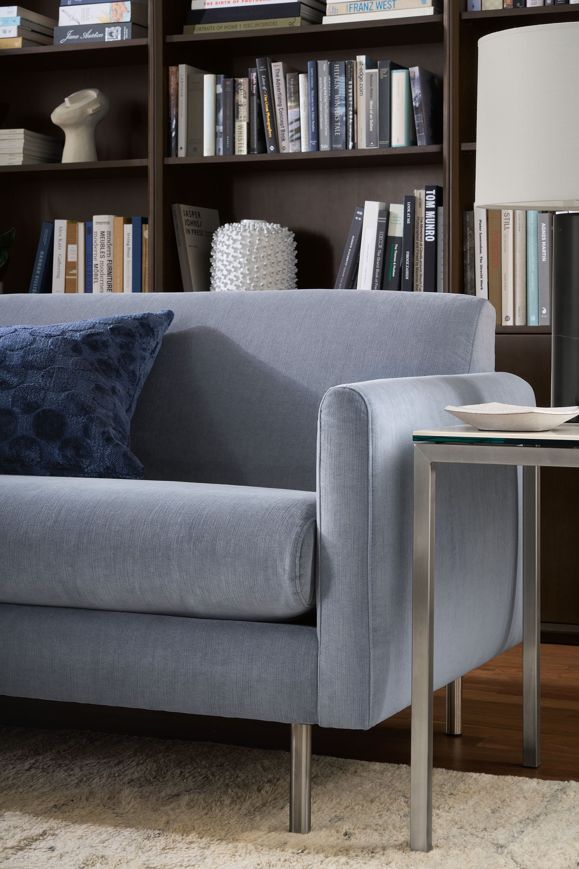 Living room with detail of Vienna sofa in windsor denim and parsons end table in stainless with white marble ceramic top.