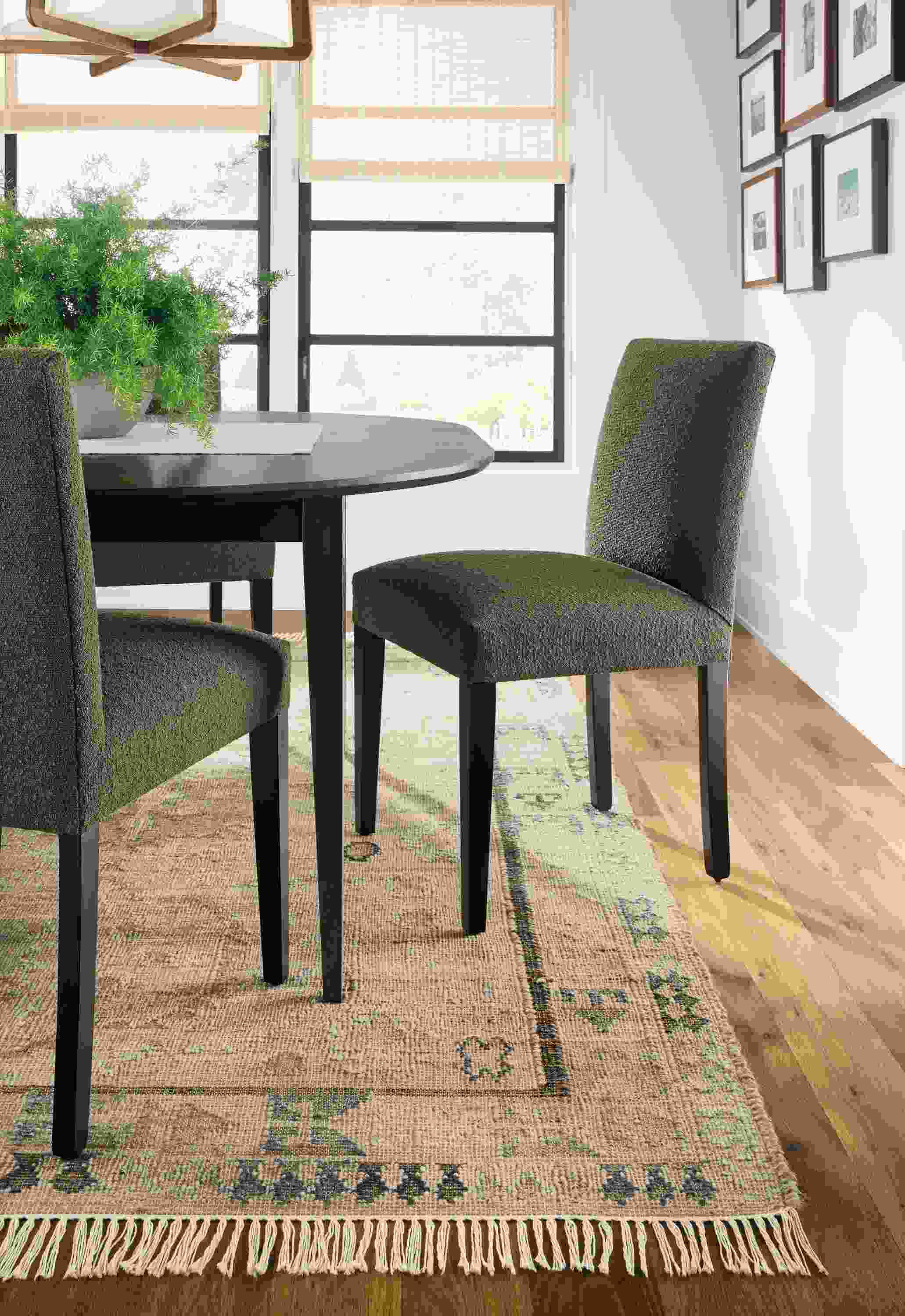 Detail of Villa rug in sand with Peyton side chairs in Declan Olive and Adams extension table in charcoal on maple.