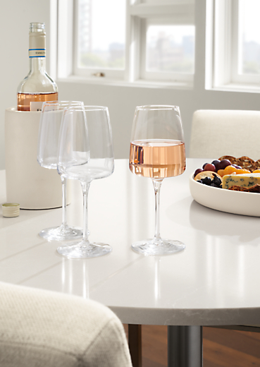detail of 3 vine wine glasses on white aria table.