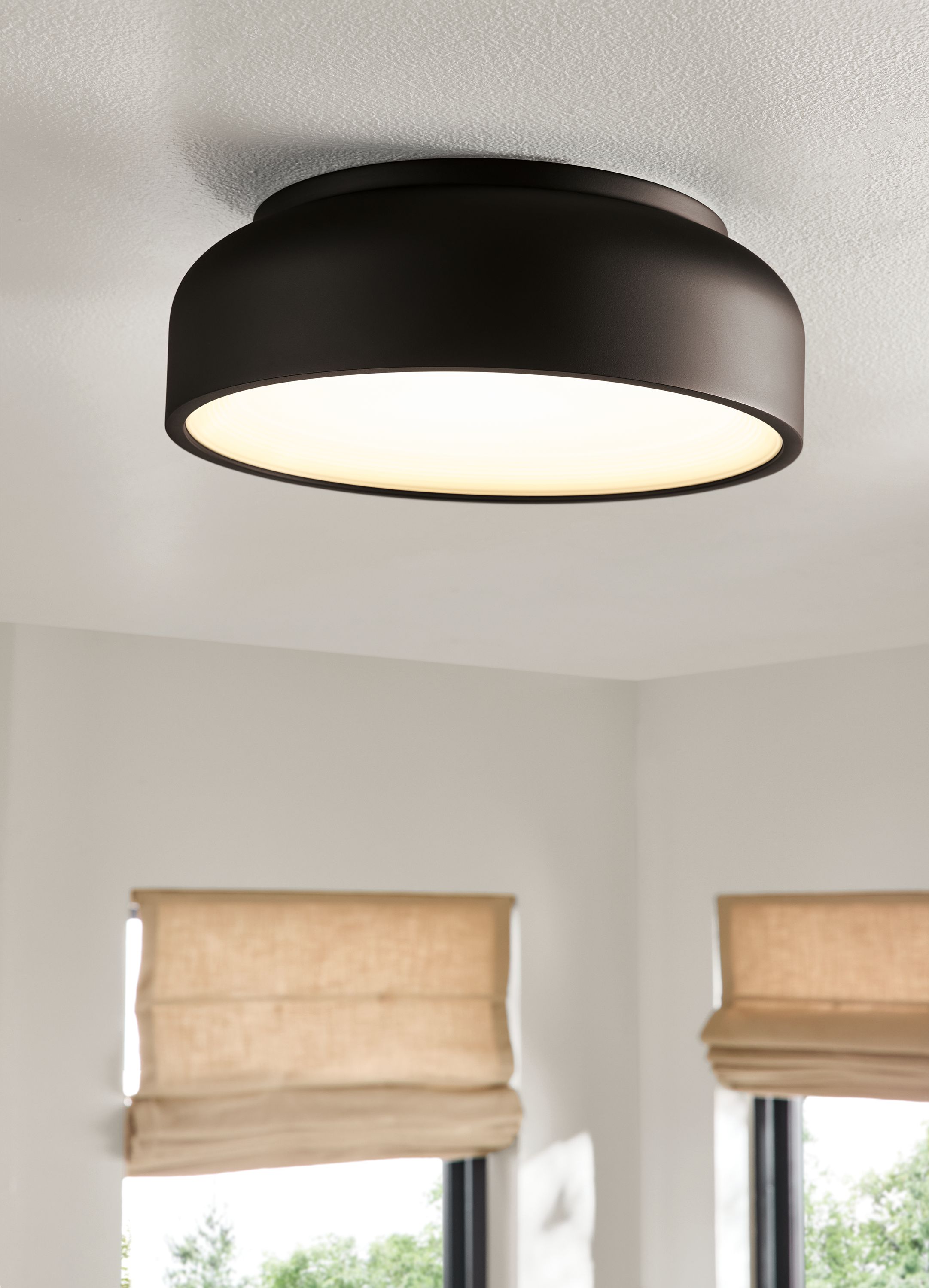 Detail of a Vitria flush mount lighting pendant in carbon mounted on a ceiling.