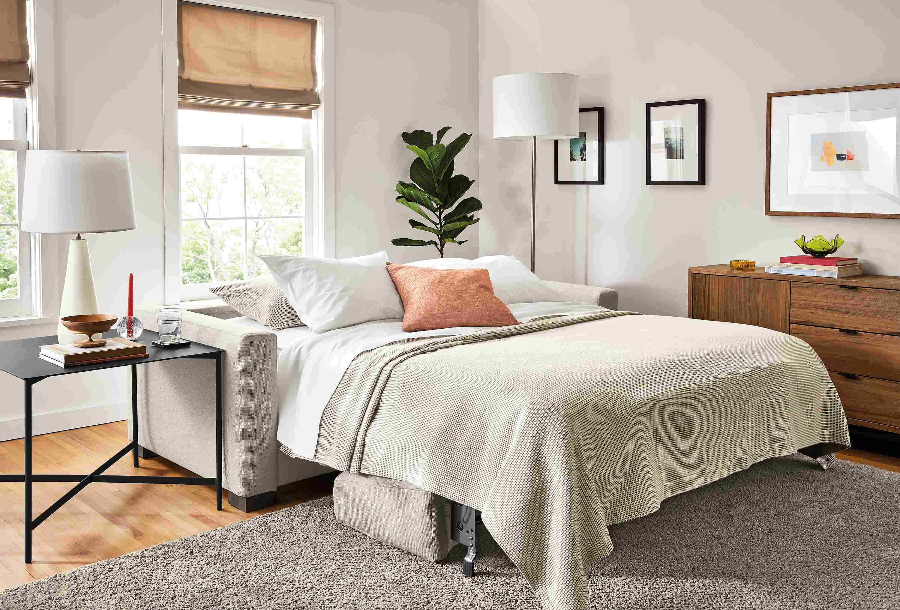 Living area with Viva fold out sleeper sofa in Sussex cement fabric made into bed with Circuit end table.