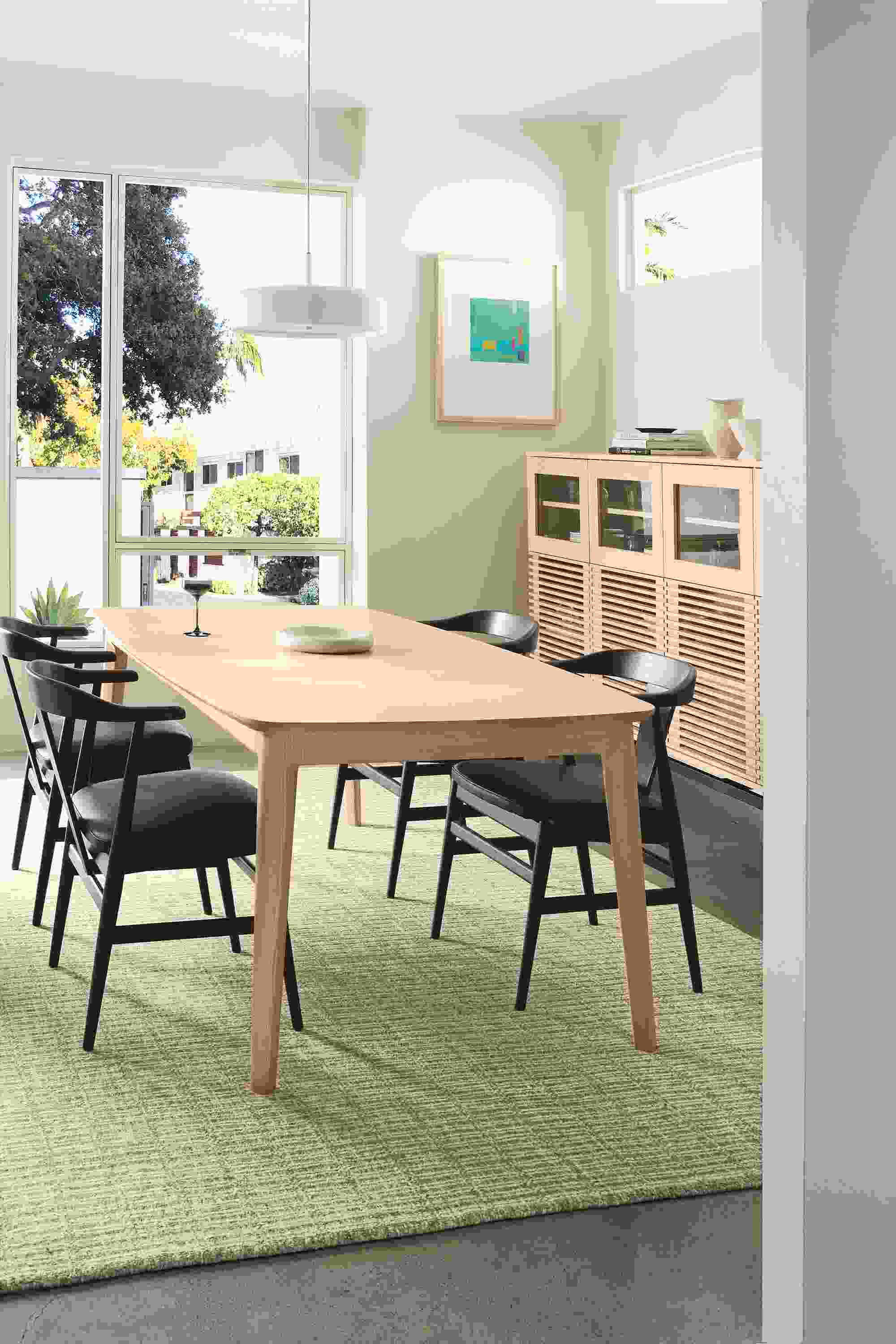 Dining room with Walcott 75-wide table in salt on red oak, 4 Evan arm chairs in charcoal and Pesaro Black leather and Nera rug.