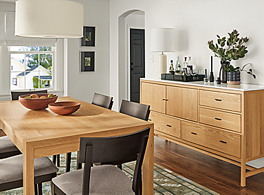 Dining area with Walsh 72-wide dining table and Berkeley 72-wide storage cabinet with quartz top in White oak and Doyle chairs.
