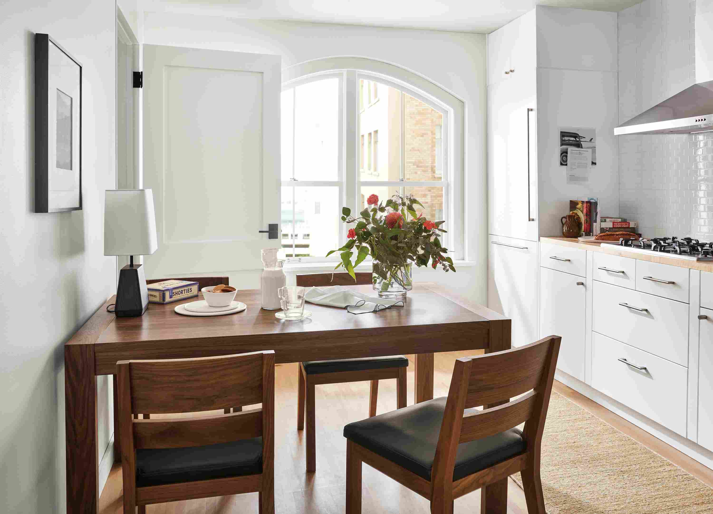 Kitchen with 60-wide Walsh dining table, Afton dining chair, Dia rugand Nadia dishes in white.