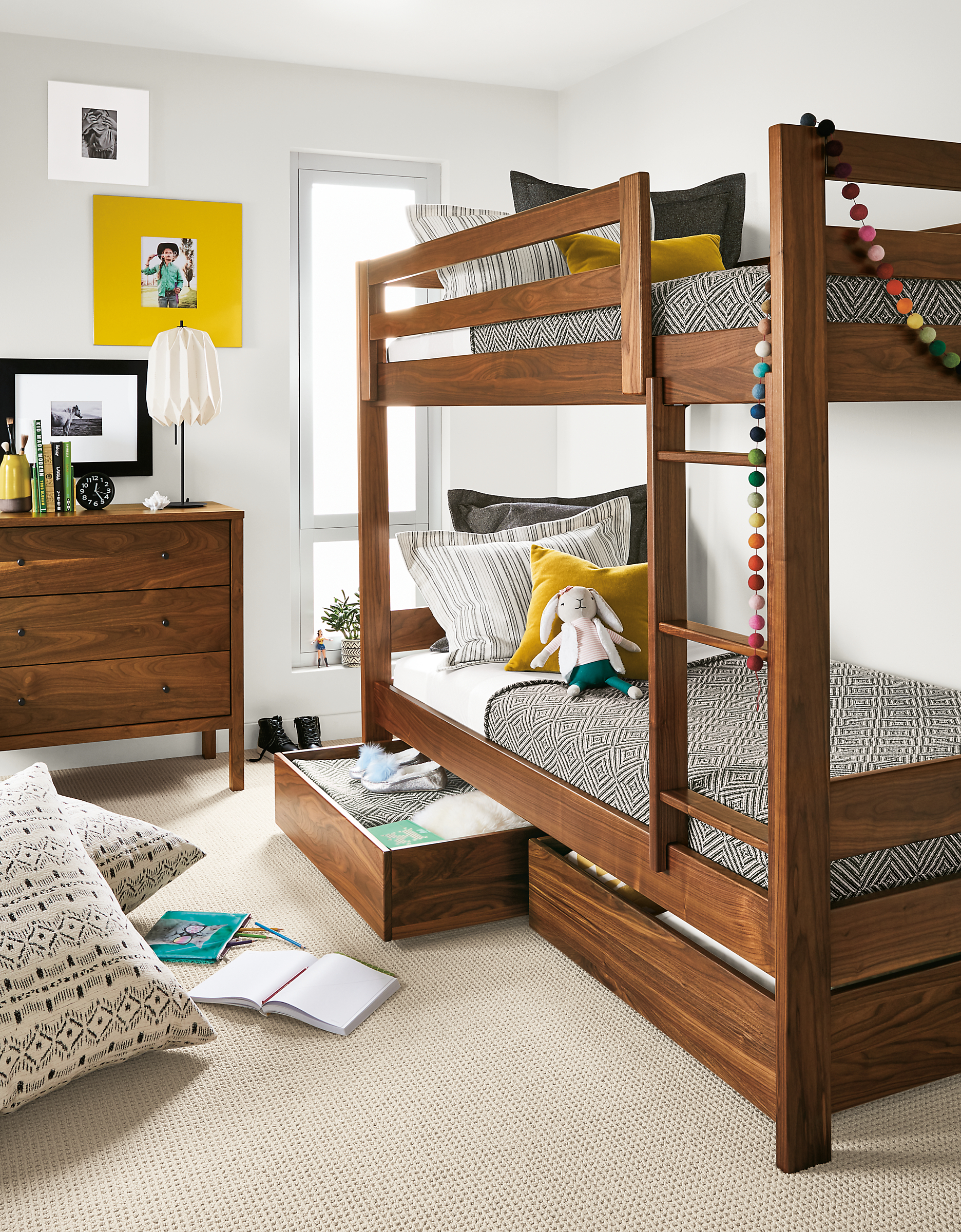 Detail of Waverly twin bunk in walnut in kids' bedroom with left trundle open.
