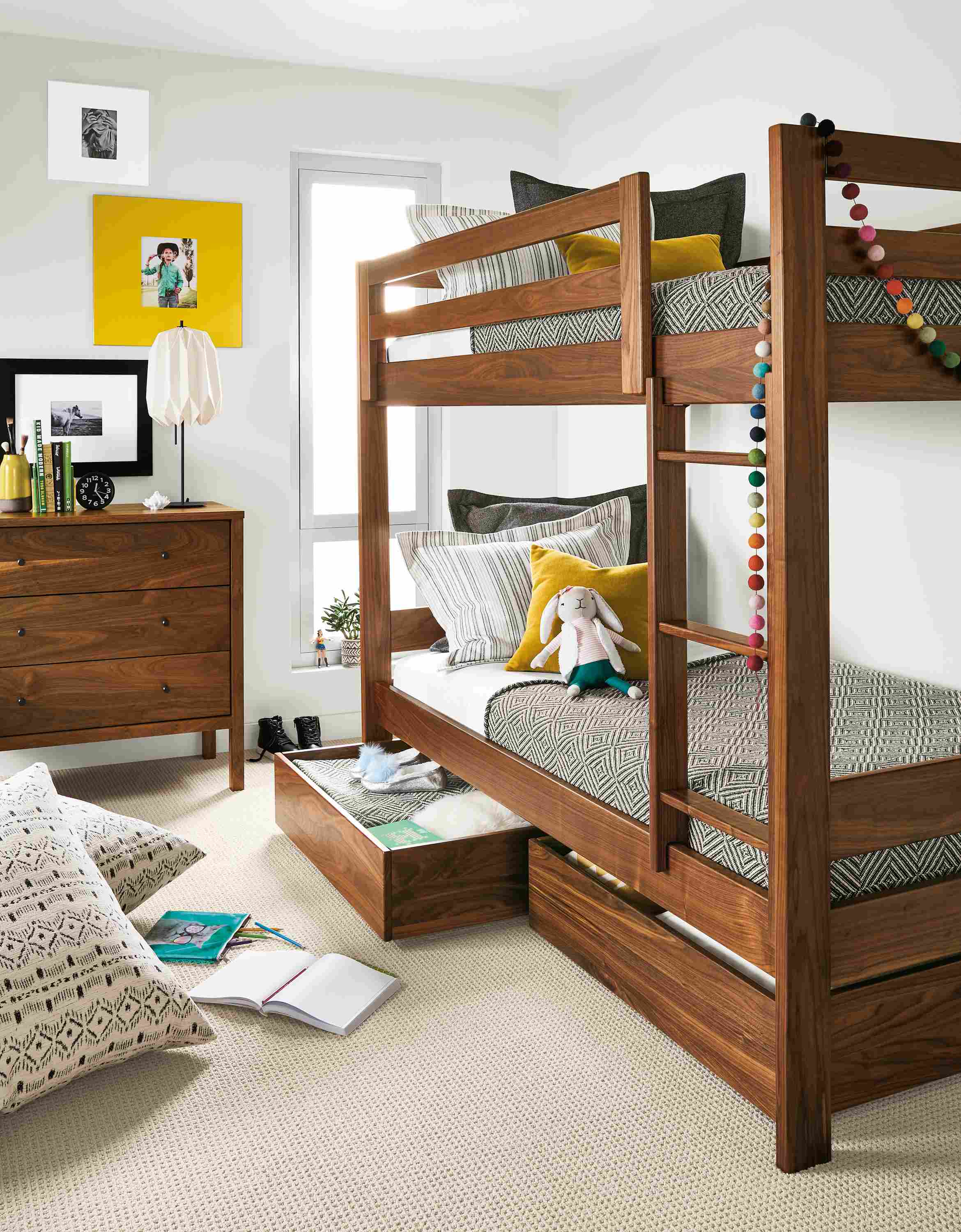 Detail of Waverly twin bunk in walnut in kids' bedroom with left trundle open.