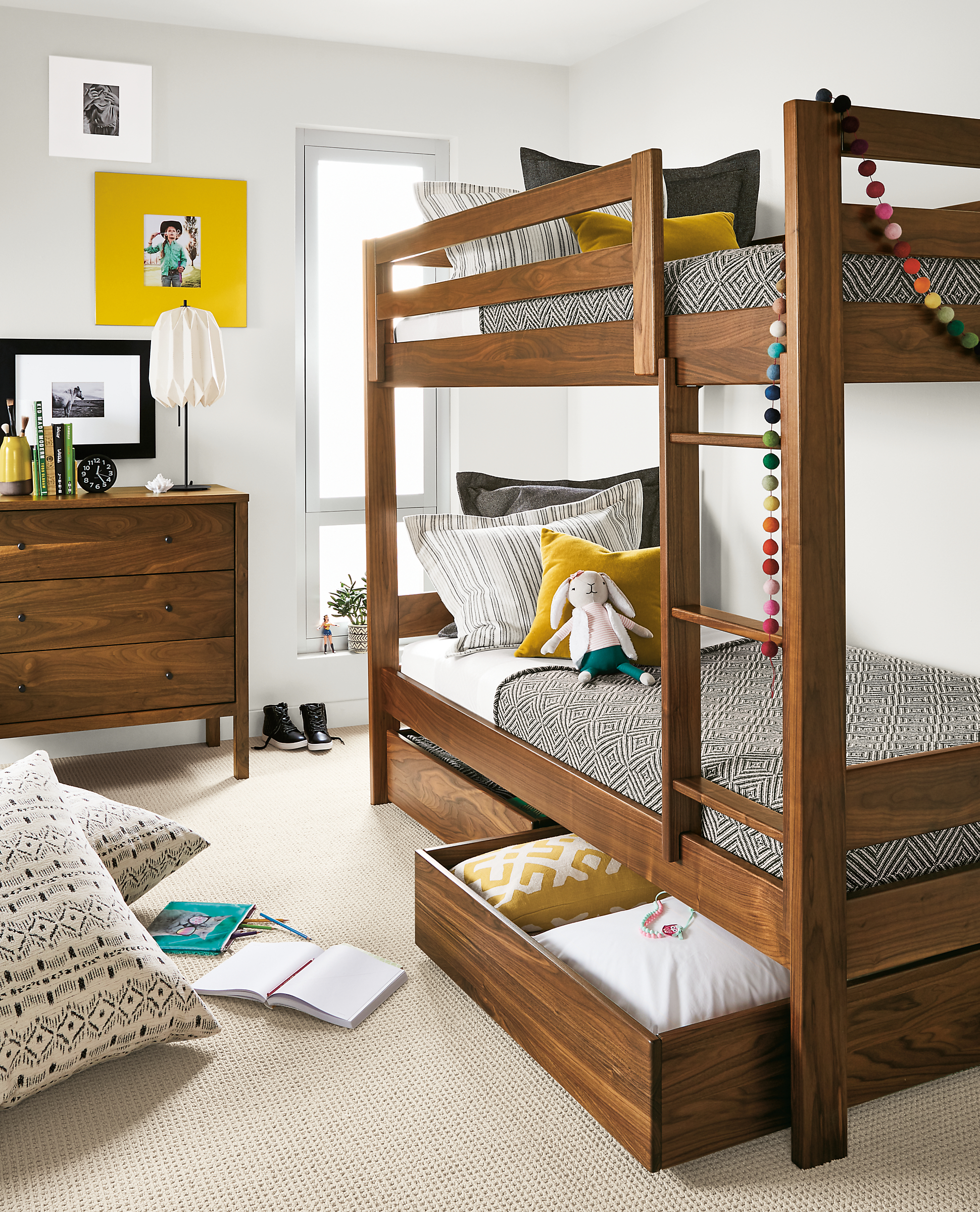 Detail of Waverly twin bunk in walnut in kids' bedroom with right trundle open.