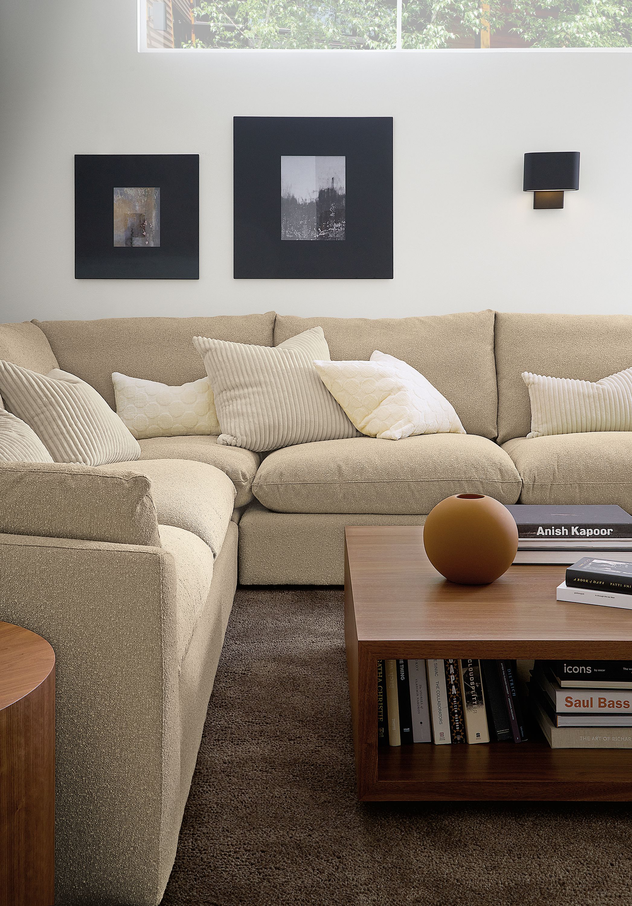 Living room with Weber sectional in Declan Camel, Graham coffee table in walnut and Arden rug in earth.