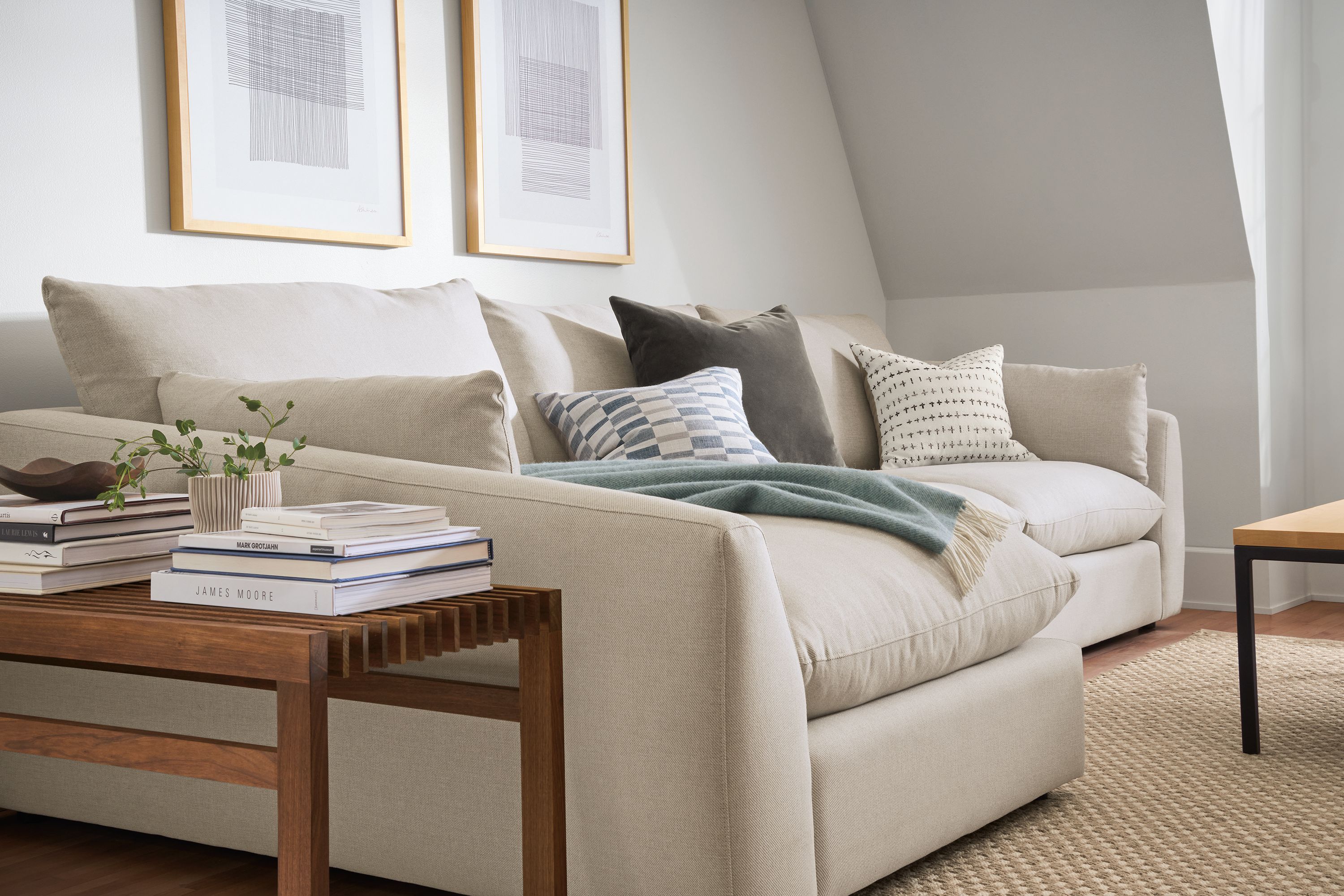 Weber sofa with chaise in Gino Oatmeal in living room with Ewing bench in walnut.
