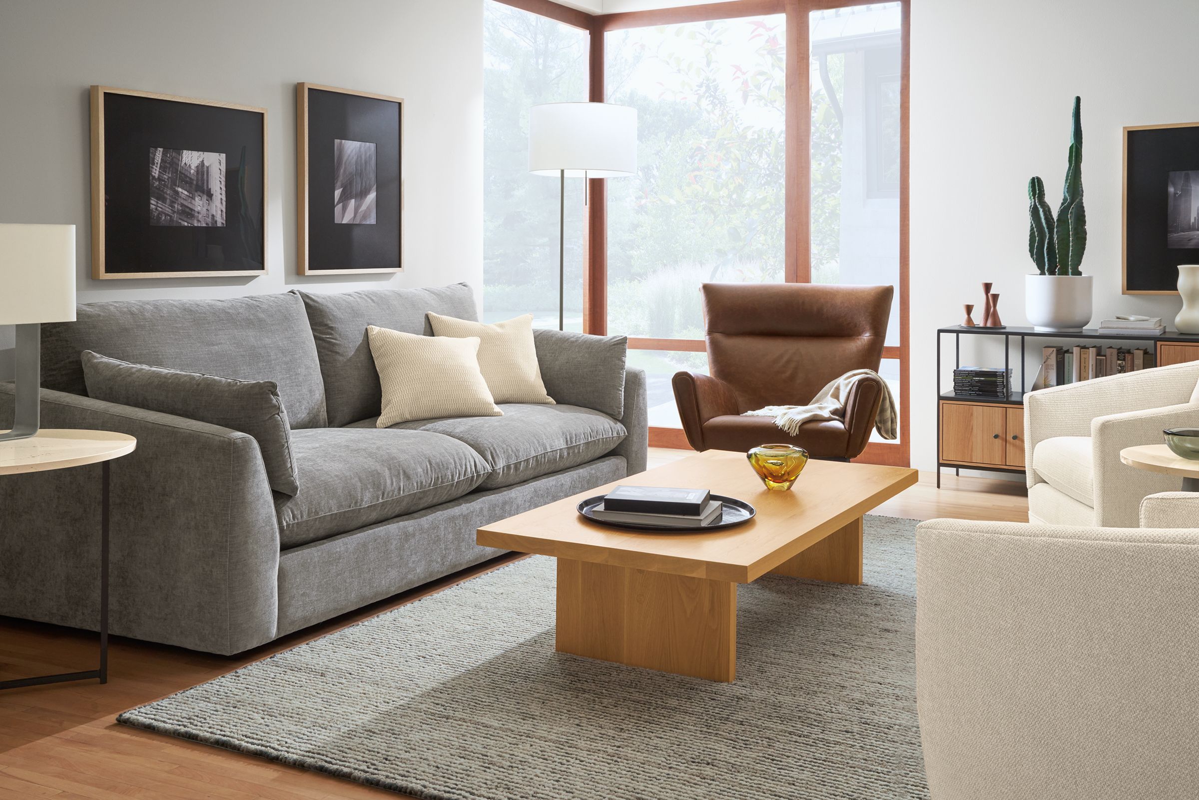 living room with weber sofa in mori graphite fabric, boden chair in leather and corbett coffee table in  white oak.