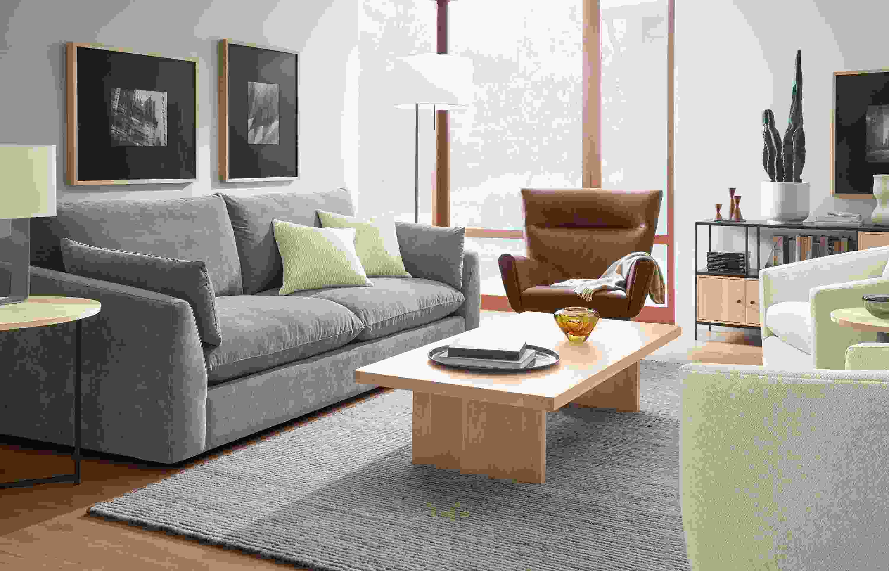 Living room with Weber sofa in Mori Graphite, Boden chair in Palermo Bourbon leather and Corbett Coffee table in  white oak.