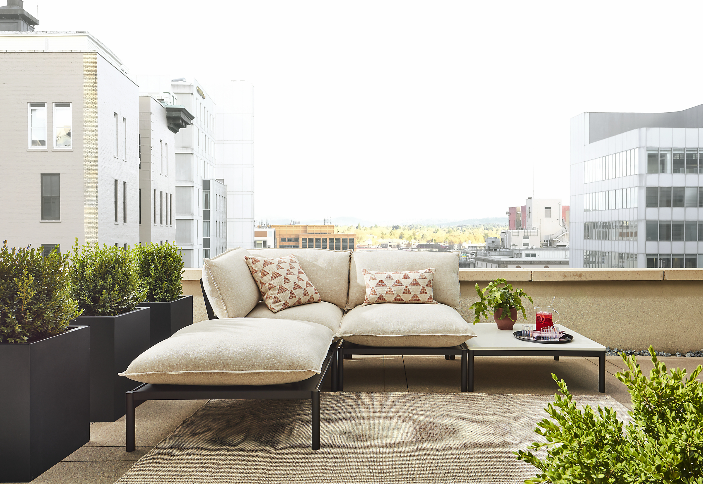 Westbrook 4-piece sectional in graphite with Nevan oatmeal cushions and marbled white quartz top on outdoor balcony.