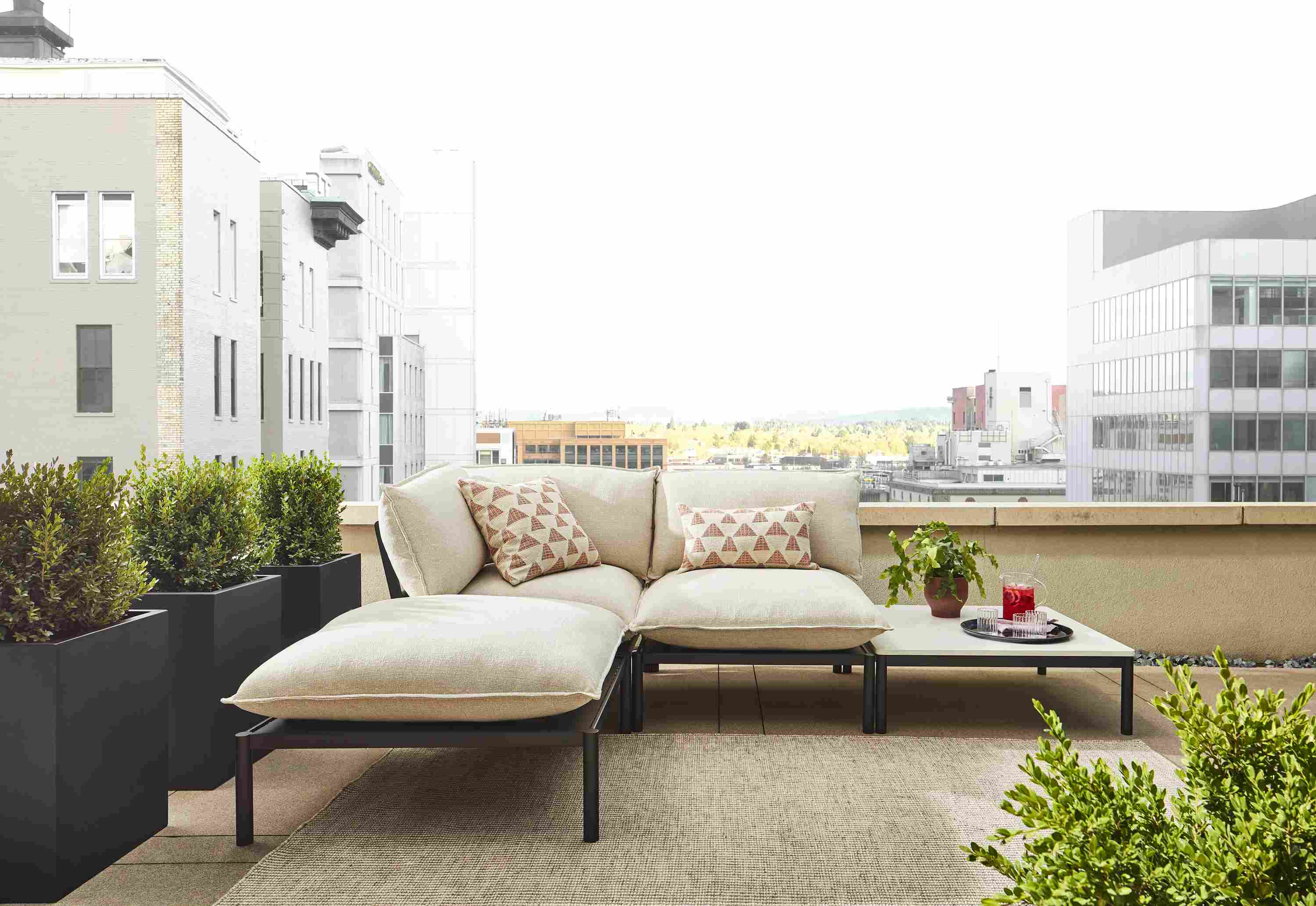 Westbrook 4-piece sectional in graphite with Nevan oatmeal cushions and marbled white quartz top on rooftop patio.