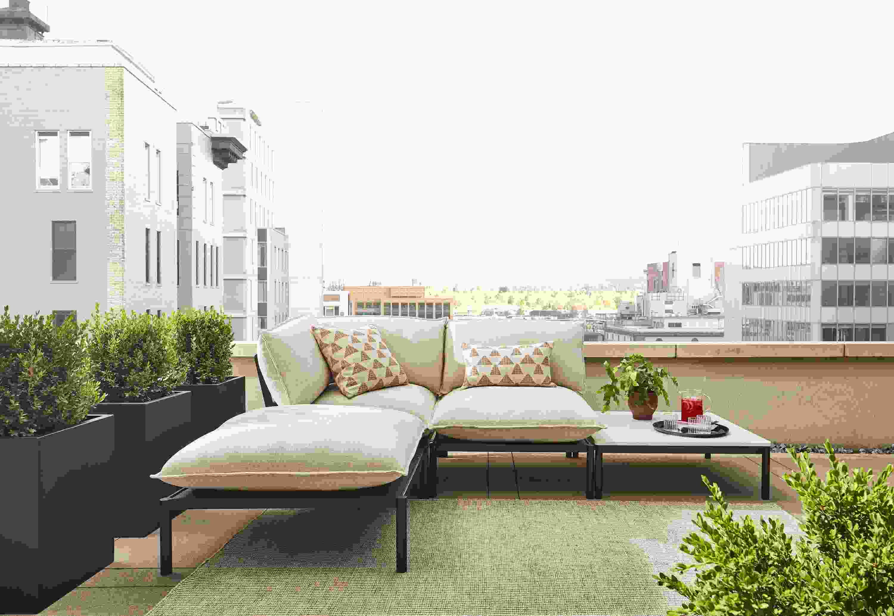 Westbrook 4-piece sectional in graphite with Nevan oatmeal cushions and marbled white quartz top on rooftop patio.
