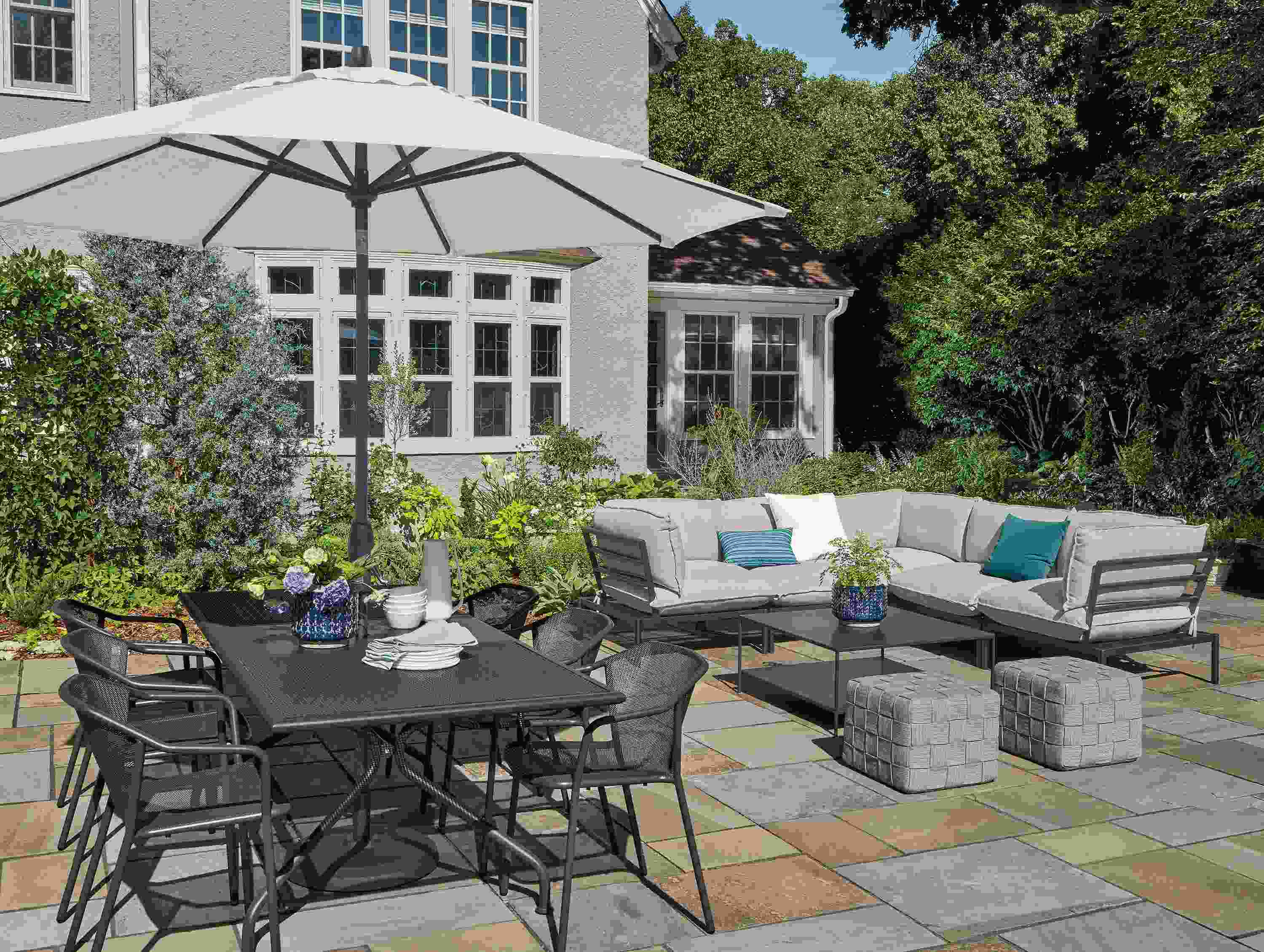Large paver patio with Kona extension table, Theo dining chairs and Westbrook sectional sofa.