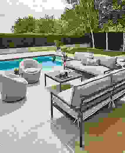 Two Westbrook outdoor sofas in graphite with Mist grey cushions, two Crest swivel chairs and Westbrook coffee table with Elegant grey granite top.