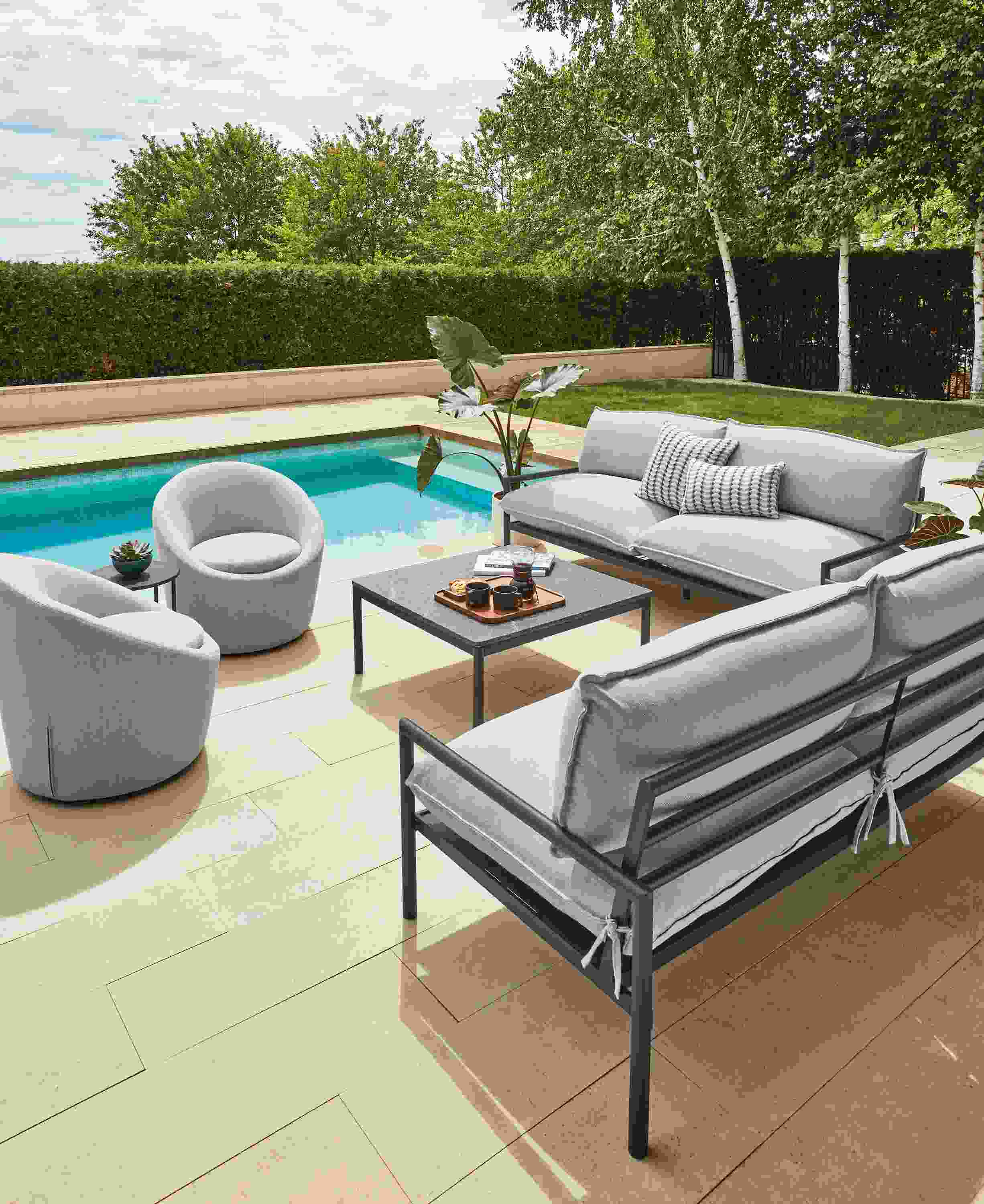 Two Westbrook outdoor sofas in graphite with Mist grey cushions, two Crest swivel chairs and Westbrook coffee table with Elegant grey granite top.