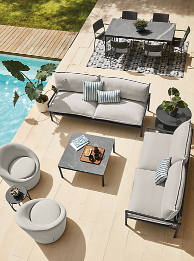 Two Westbrook outdoor sofas in graphite with Mist grey cushions, Westbrook coffee table with Elegant grey granite top and two Crest swivel chairs.