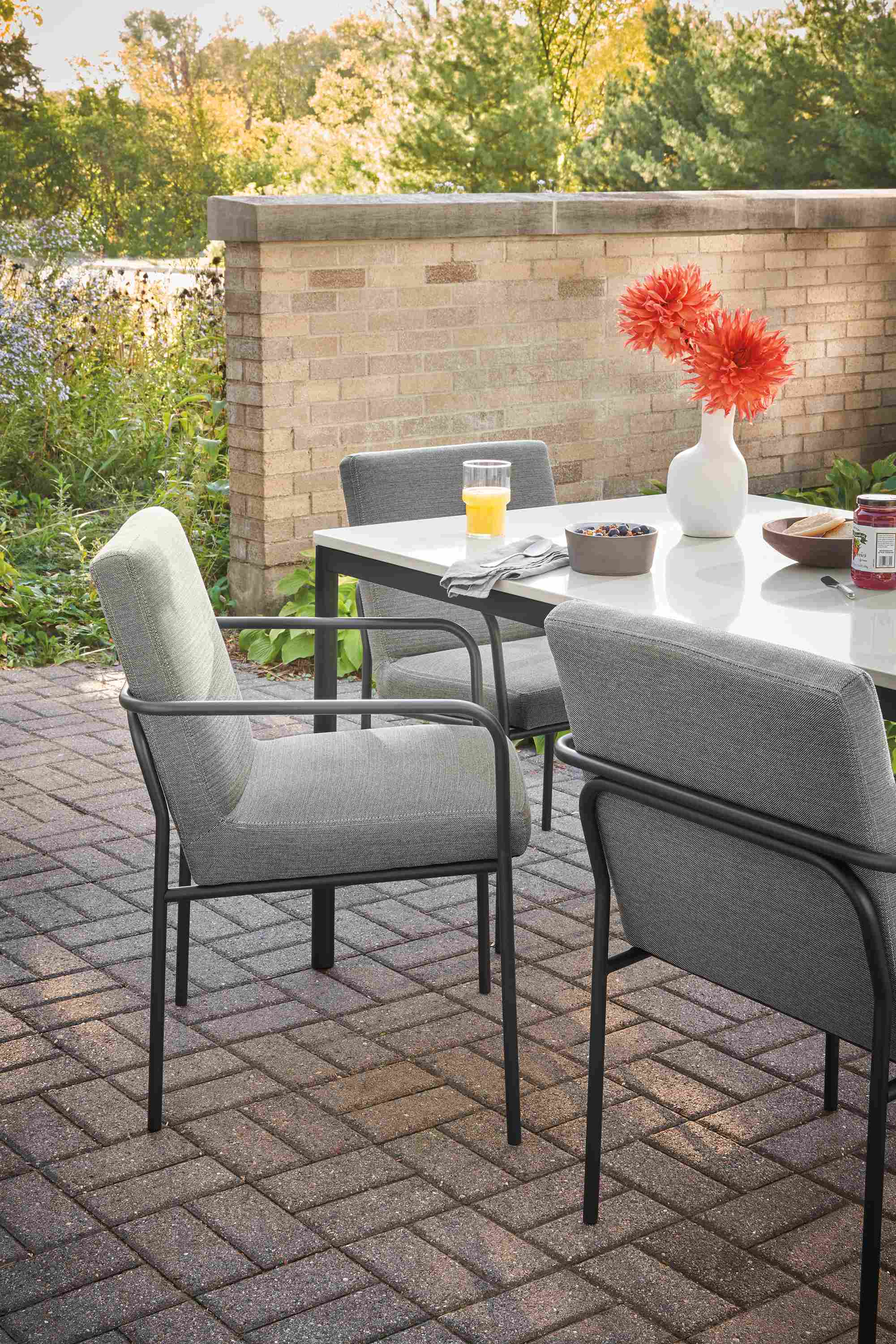 Outdoor dining space with Joel armchairs in Pelham Graphite fabric, and Westbrook table.