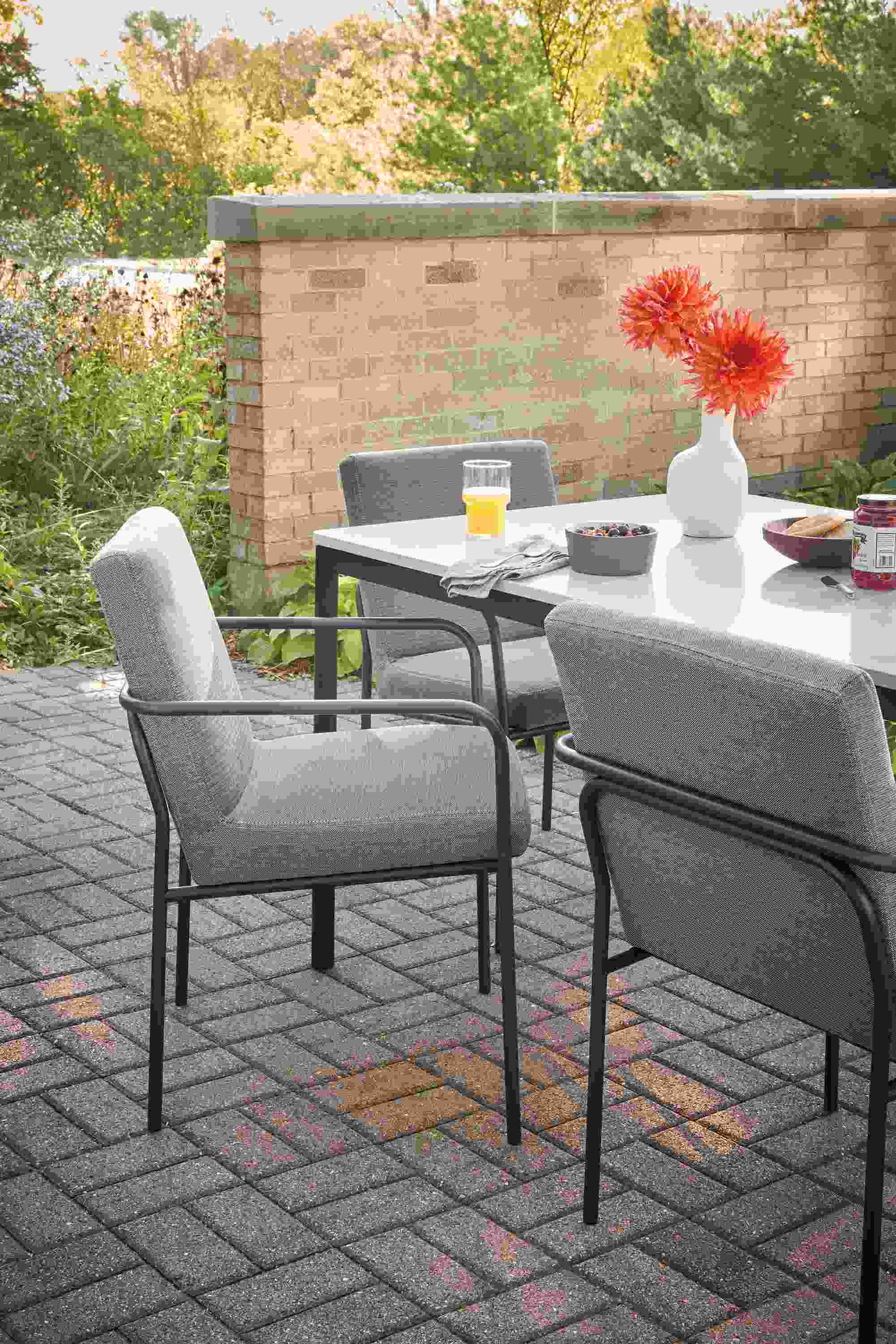 Outdoor dining space with Joel armchairs in Pelham Graphite fabric, and Westbrook table.