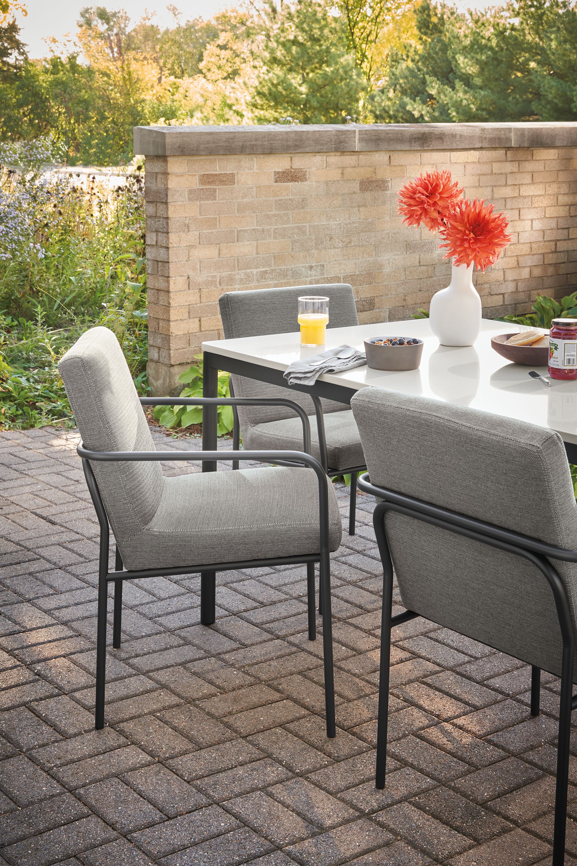 outdoor dining space with joel armchairs in pelham graphite fabric, and Westbrook table.