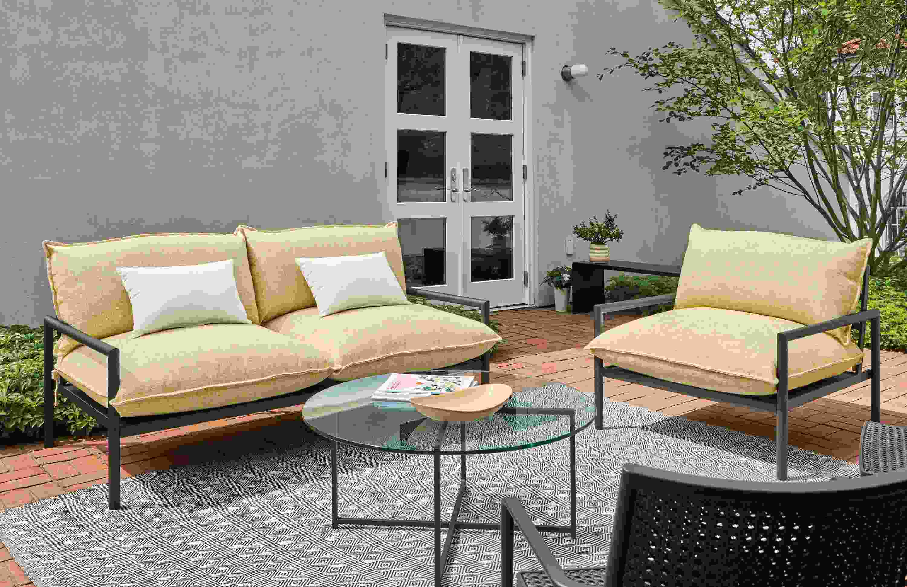 Brick patio with Westbrook 67-wide sofa, Westbrook lounge chair, classic coffee table and hue pillows.