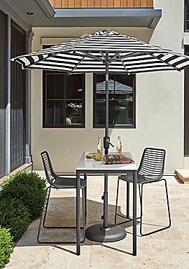 Westbrook 48-wide outdoor counter table in graphite with marbled white quartz top, umbrella in Watts ebony fabric and two Mini outdoor counter stools in dark grey.