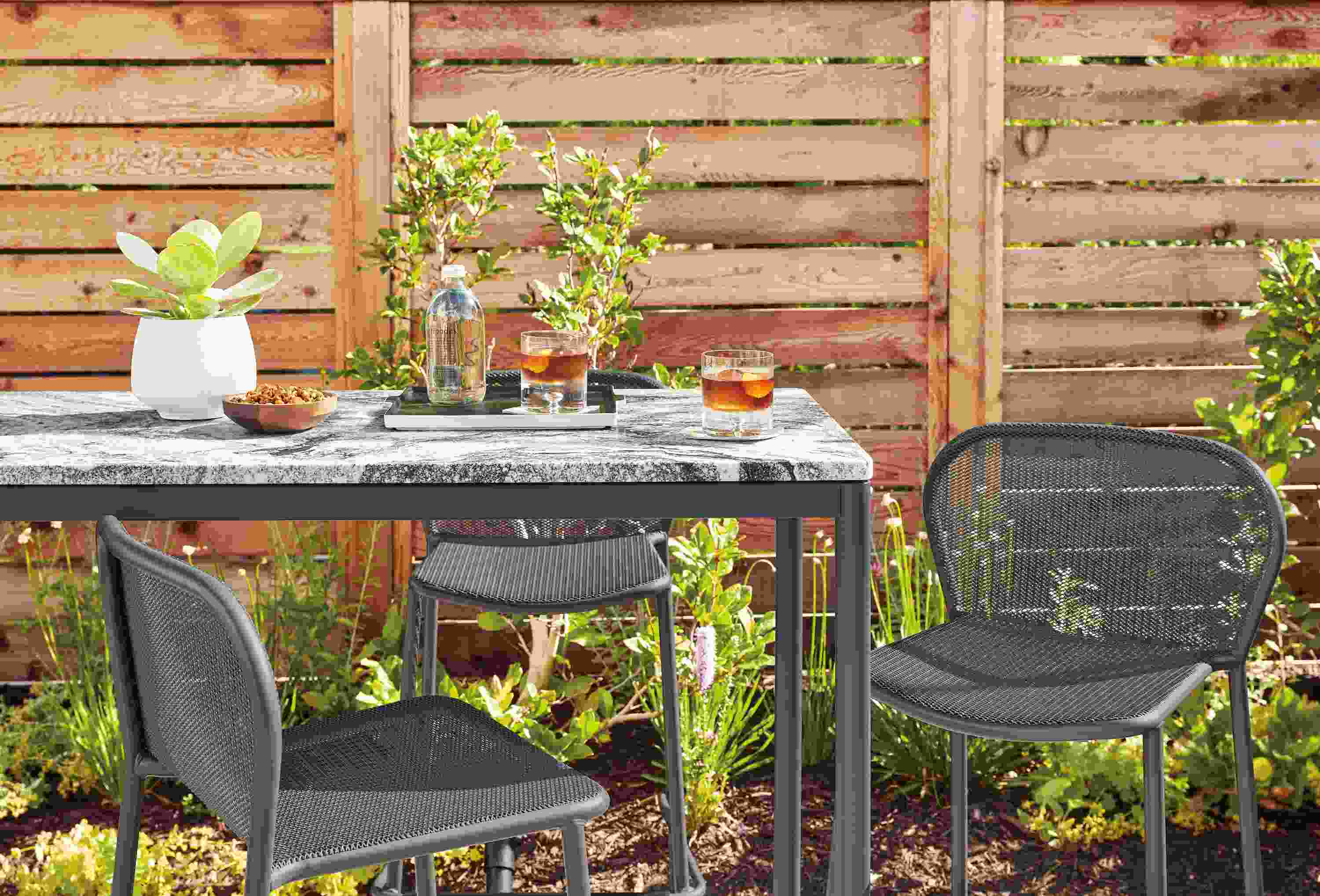 Westbrook 48-wide outdoor bar table in graphite with Wiscont white granite top and three theo bar stools in graphite.