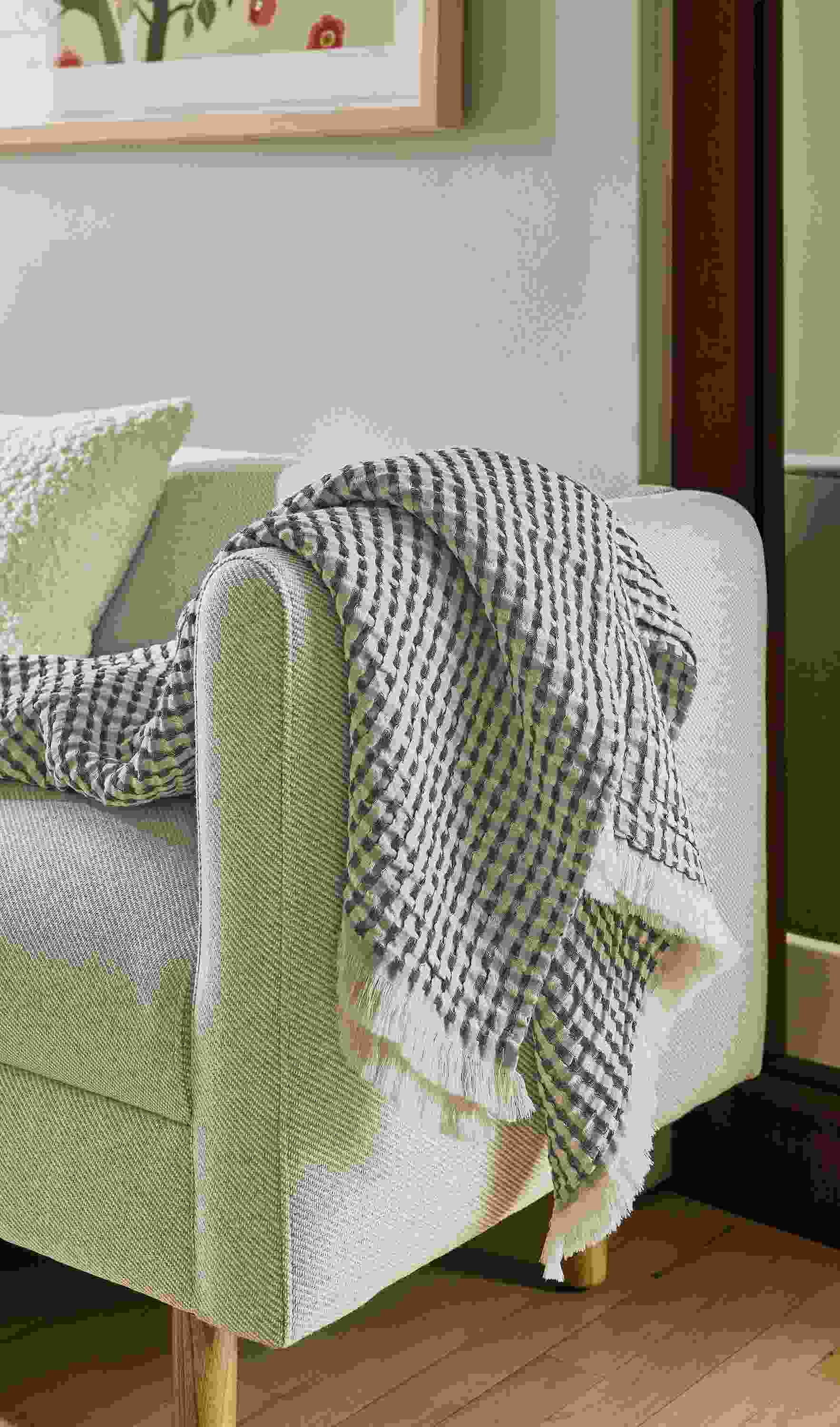 Westin throw blanket in slate draped over the arm of a Satler 60-wide bench in Derry Natural.