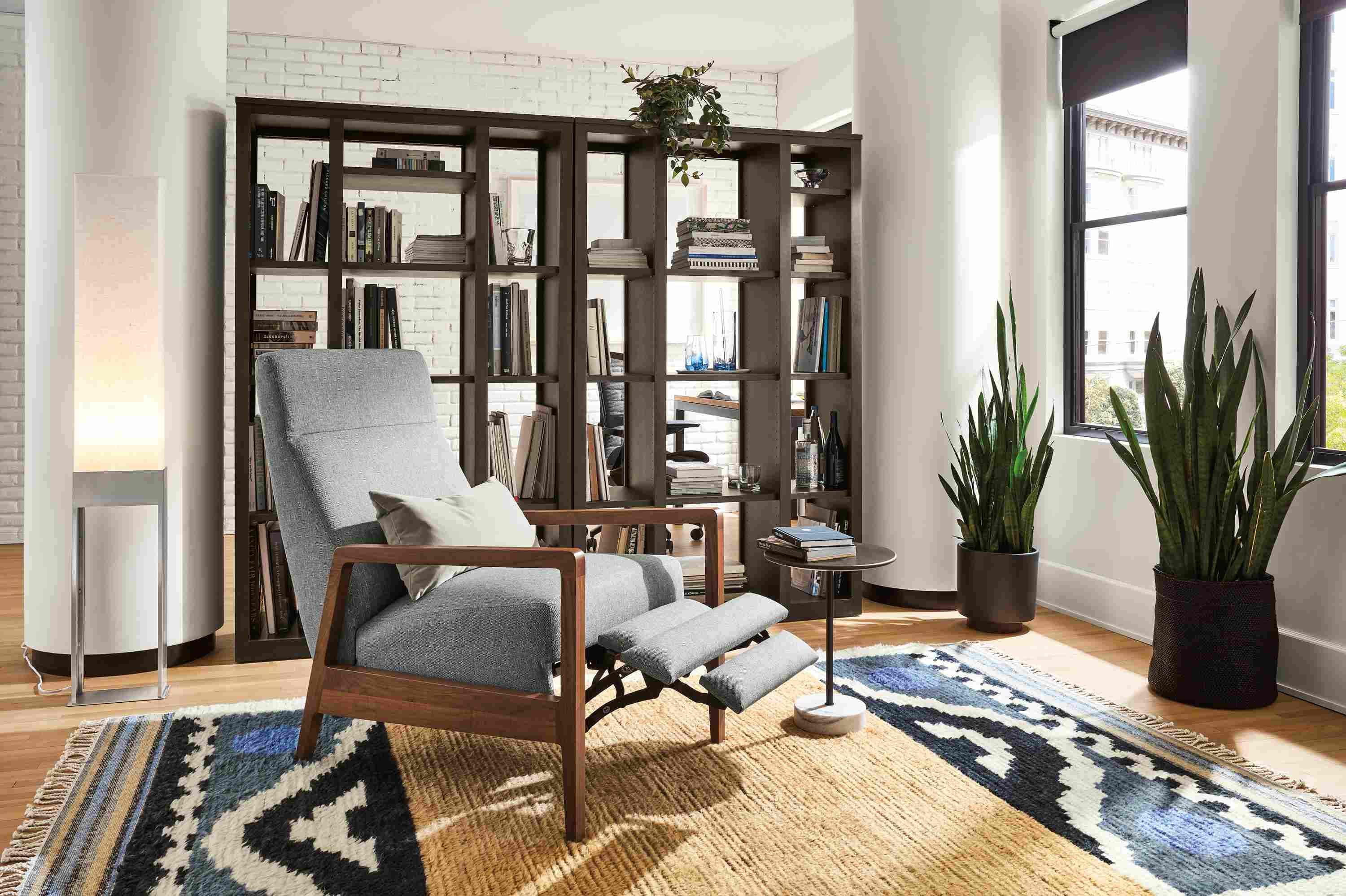 Living room with Westport recliner shown with footrest extended, Woodwind bookcases, and Parsons table.