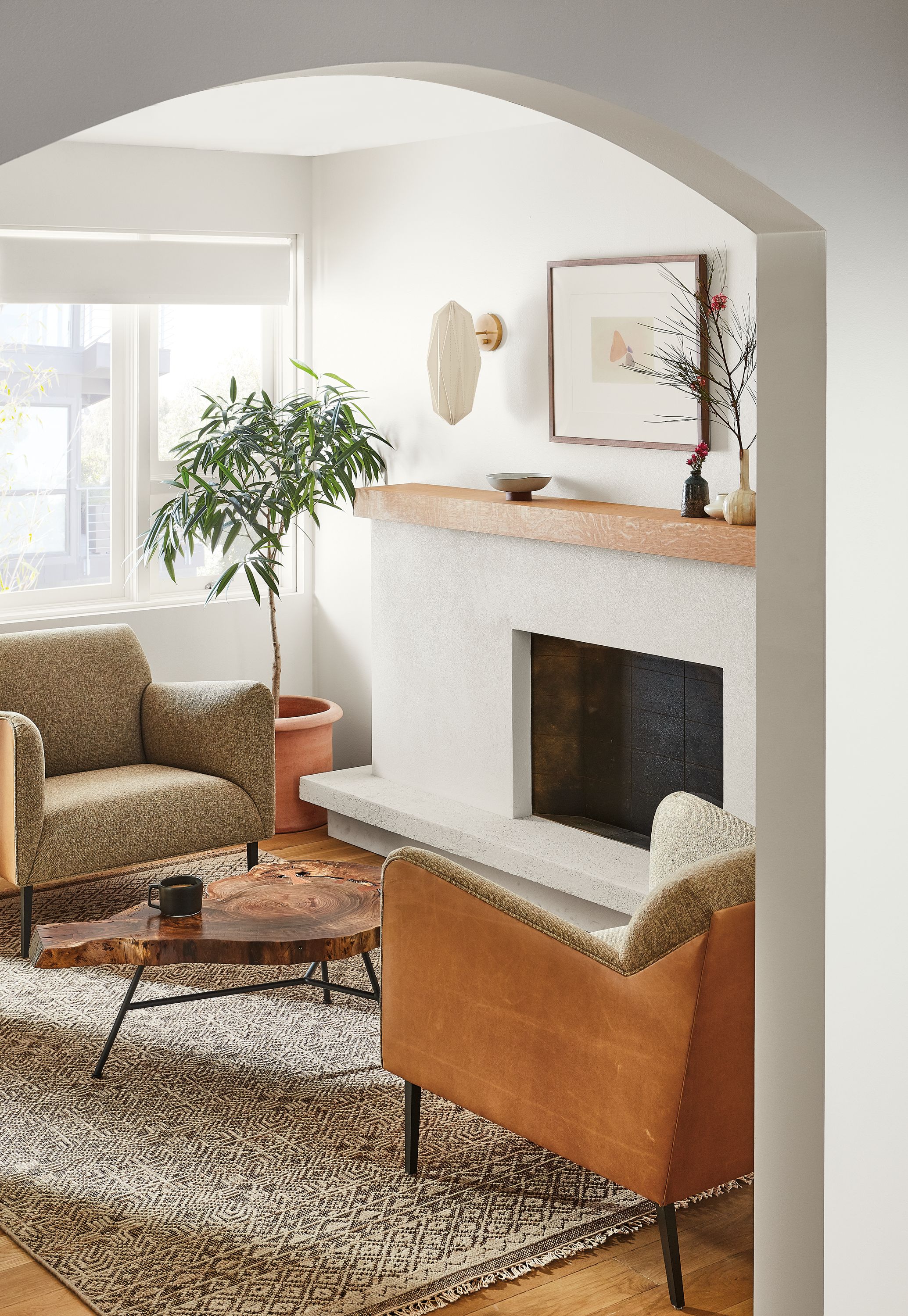 Living room with detail of wheatland coffee table, matteo chair, anu rug, orikata sconce.