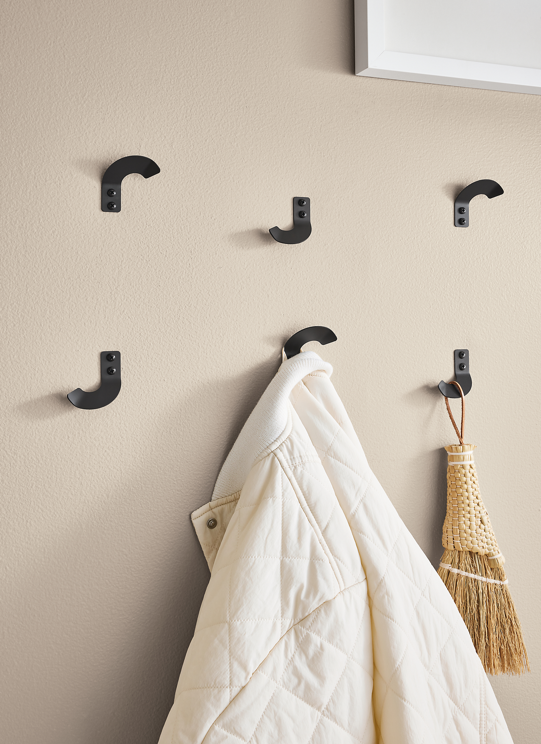 Six Whim wall hooks arranged in eclectic pattern on entryway wall.