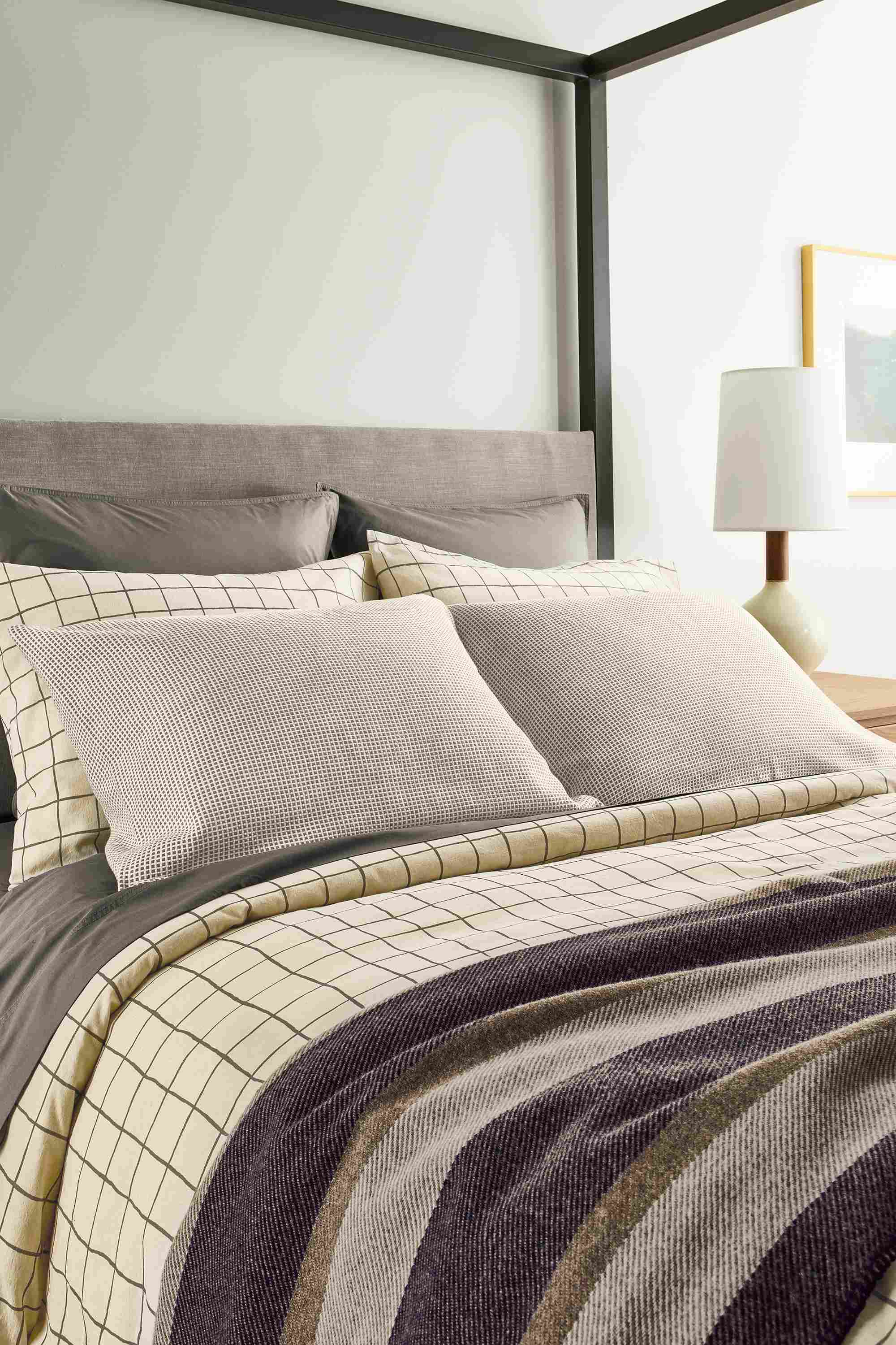 Bedroom with detail of window duvet set in charcoal, washable wool blanket in navy and mara sham in ivory/grey.