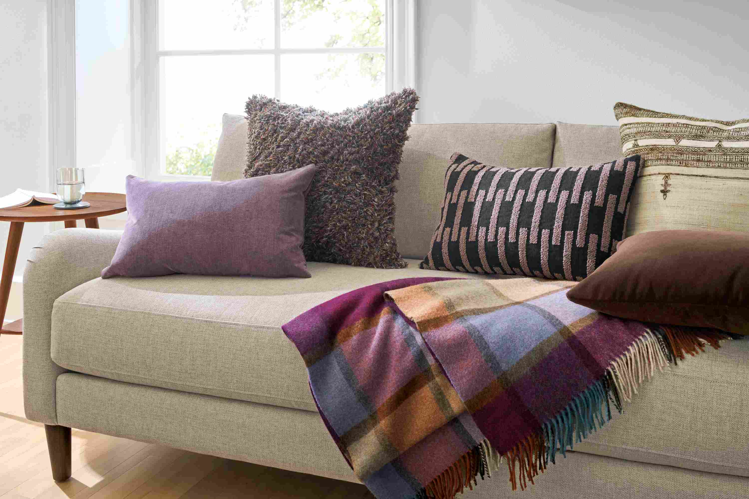 Living room with Windsor, Vinten, Ida and Bhujodi throw pillows on an Eloise sofa in Sumner Flax.
